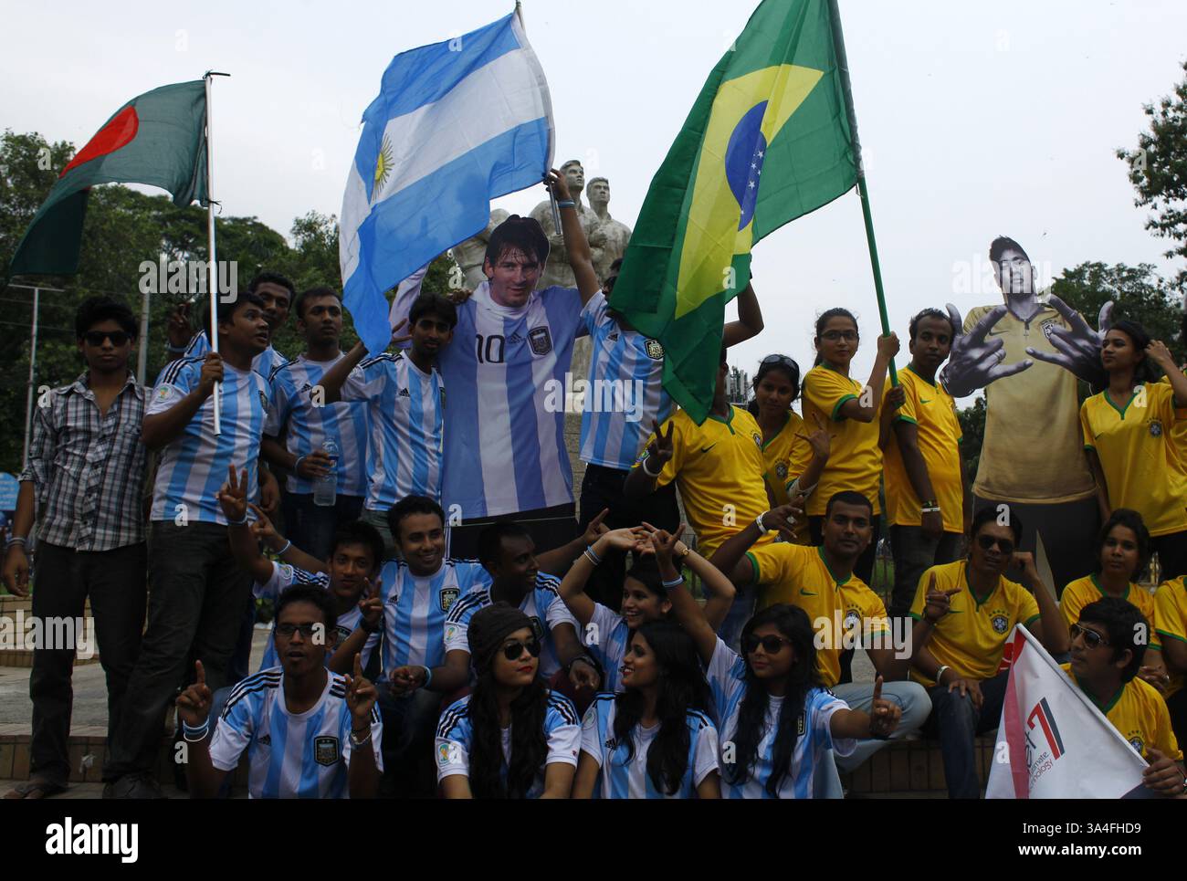 10. Juni 2014 - Dhaka, Bangladesch - die Anhänger der argentinischen und brasilianischen Mannschaft trafen sich auf der Straße mit dem Trikot ihrer Lieblingsmannschaft. Die Weltmeisterschaft steht wieder auf dem Programm und bringt den überwältigenden Spielgeist und die Hitzewellen des „Fußballfiebers“ von Brasilien nach Dhaka mit sich. Die knapp zwanzig Millionen Einwohner der Hauptstadt Bangladeschs feiern mit großem Interesse die Weltmeisterschaft. Zahlreiche Flaggen der teilnehmenden Nationen winken auf den Straßen und auf den Dächern der Häuser, Geschäfte und sogar Büros. Die erscheinenden Mannschaftstrikots und andere Produkte im Zusammenhang mit der Weltmeisterschaft werden gerade dabei sein Stockfoto