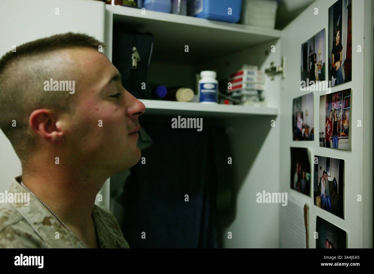 13. August 2004; Camp Ripper, Irak; PFC. BRANDON D. CARROLL, 22, ein Infanterie-Mann aus Decatur, Ala., checkt Bilder von Familie und Freunden an ihn. Carroll ist eine der vielen Marines, die mehr als einjährige Touren anbieten. Seine zweiwöchige Urlaubszeit ist weniger als einen Monat entfernt. Stockfoto