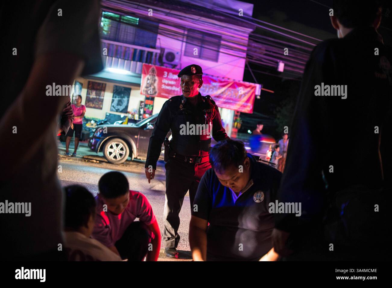 9. September 2014 - Chiang Mai, Chiang Mai, Thailand - 10. September 2014 - Chiang Mai, Thailand - Ein thailändischer Verkehrspolizist im Ausland die Behandlung eines Unfallopfers durch Notfallhelfer eines der Chiang Mai Notfallteams...bis zu 26.000 Menschen sterben jedes Jahr auf den Straßen von Thailandâ, wobei unzählige weitere verletzt werden. . Als Reaktion auf diese Flut von Unfällen haben sich Freiwilligenorganisationen unter dem Dach von Chiang Mai Emergency Rescue zusammengeschlossen und versuchen, bei der Konfrontation mit den erschütternden Statistiken zu helfen. ..stationiert in der ganzen Stadt Chiang Mai Teams von 1 Stockfoto