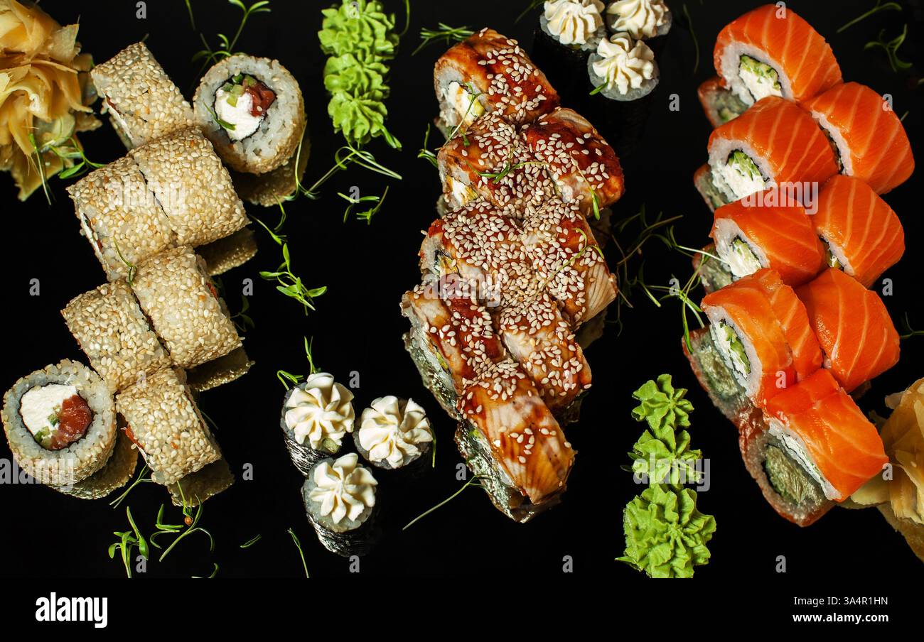 Japanisches Sushi wird auf einem dunklen Tisch gerollt. Draufsicht Stockfoto
