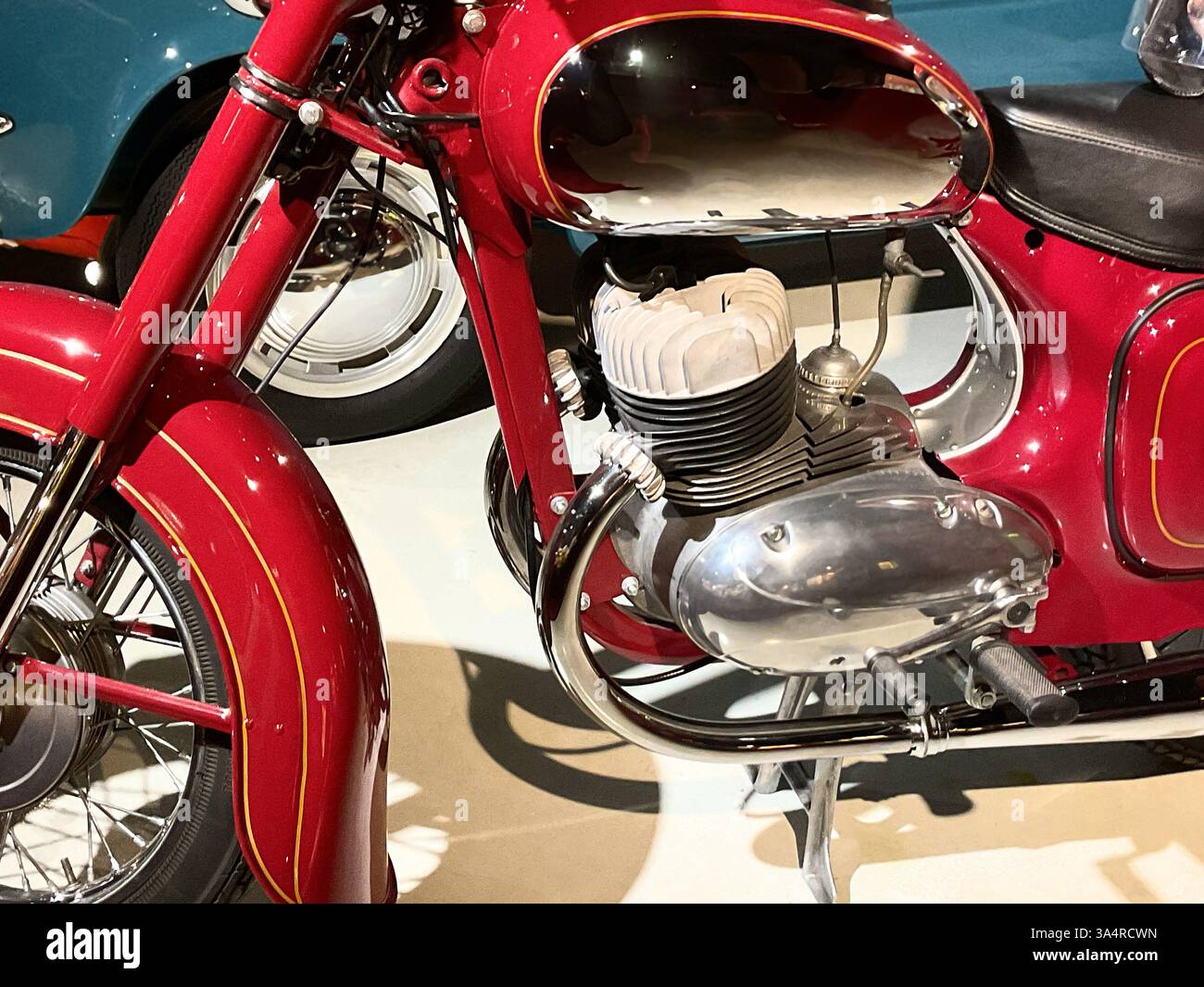 Ein klassisches rotes Motorrad mit metallischen Reflexen im Retro-Kraftstofftank aus poliertem Chrom und raffinierten Details an Kotflügeln und Karosserie, perfekt für Stockfoto