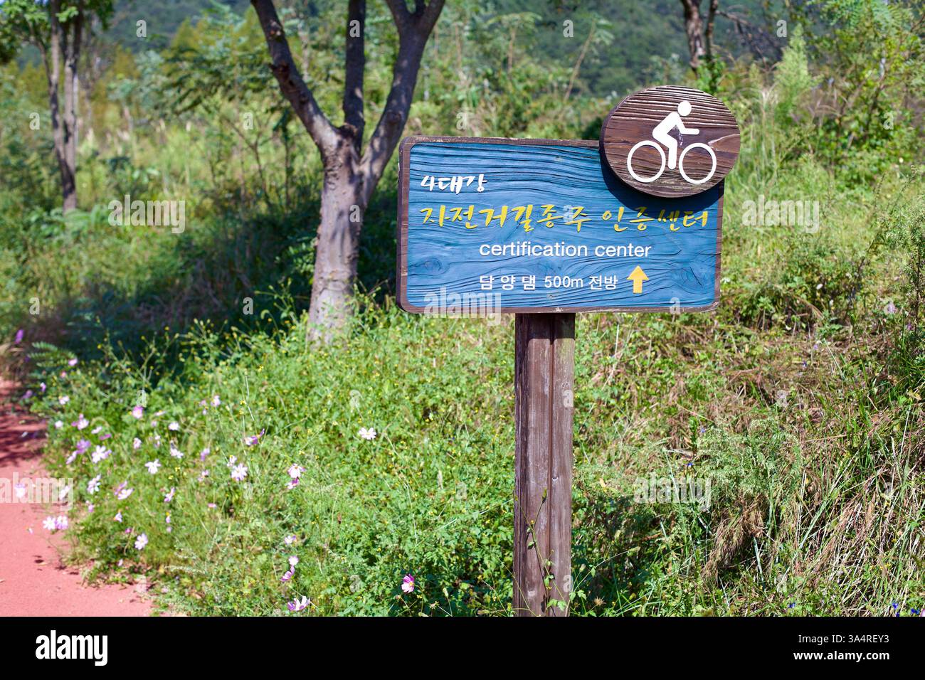 Damyang County, Südkorea - 23. September 2020: Ein hölzerner Wegweiser entlang des Yeongsangang Bike Path weist Radfahrer in Richtung Damyang Dam-Zertifikat Stockfoto