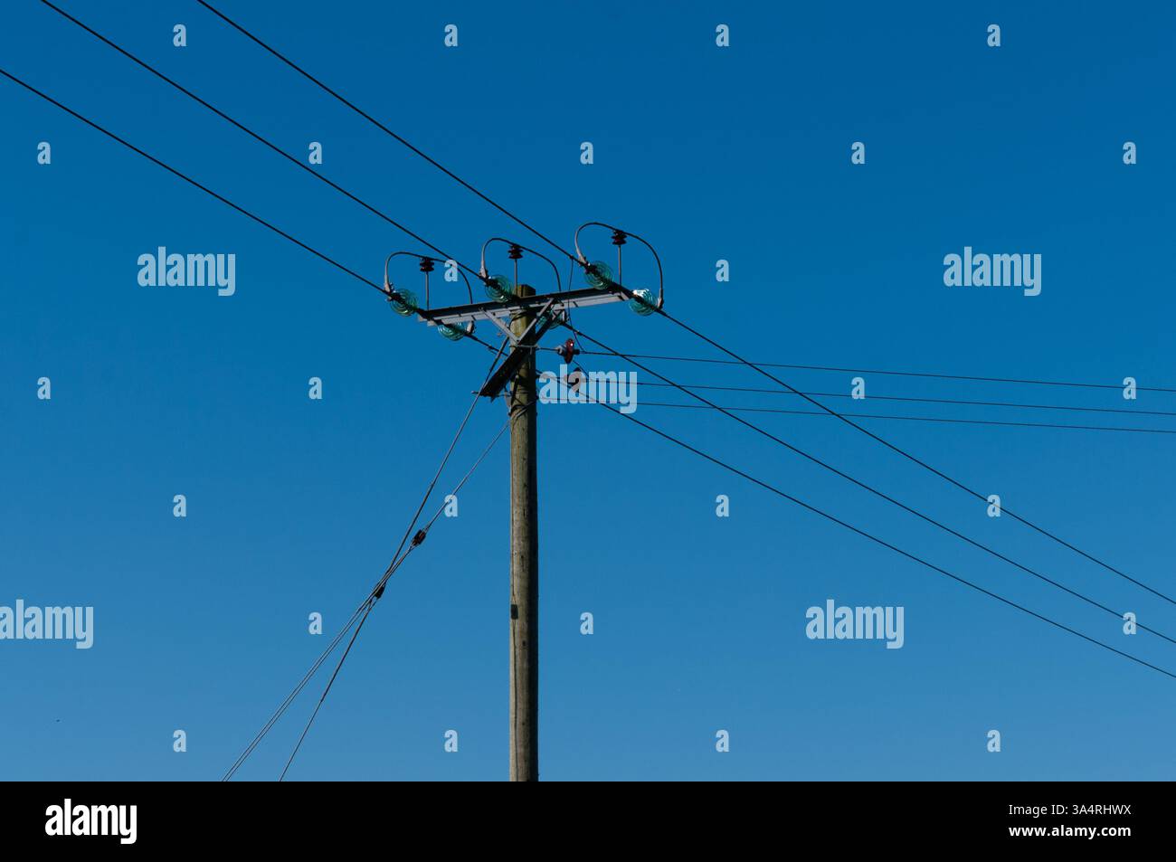 Örtliche Verbindung von Stromleitungen aus dem Stromnetz an einem Versorgungsmast. Stockfoto