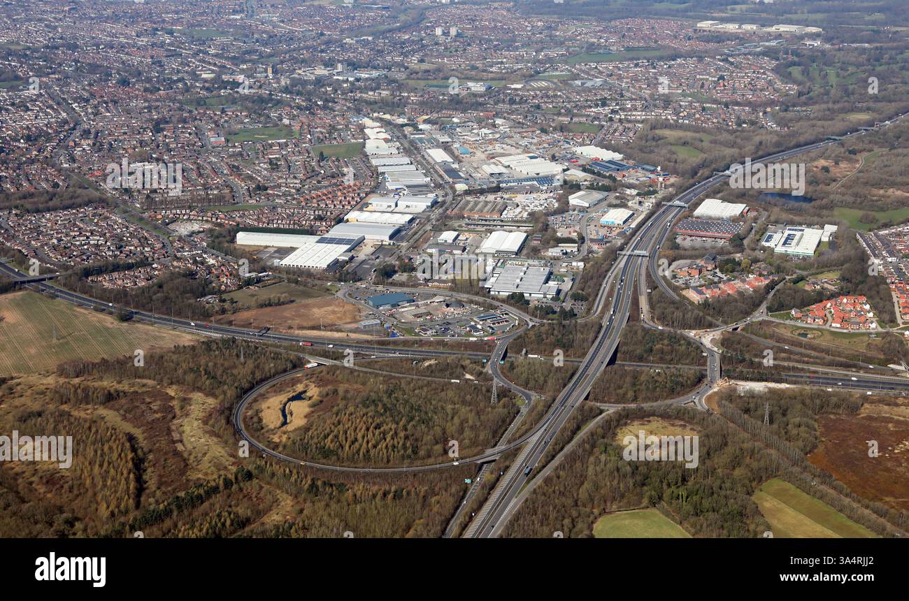 Luftaufnahme des Autobahnkreuzes M57 (Anschlussstelle 1) und M62 (J6). Das Industriegebiet Interchange Motorway befindet sich im Hintergrund. Liverpool. Stockfoto