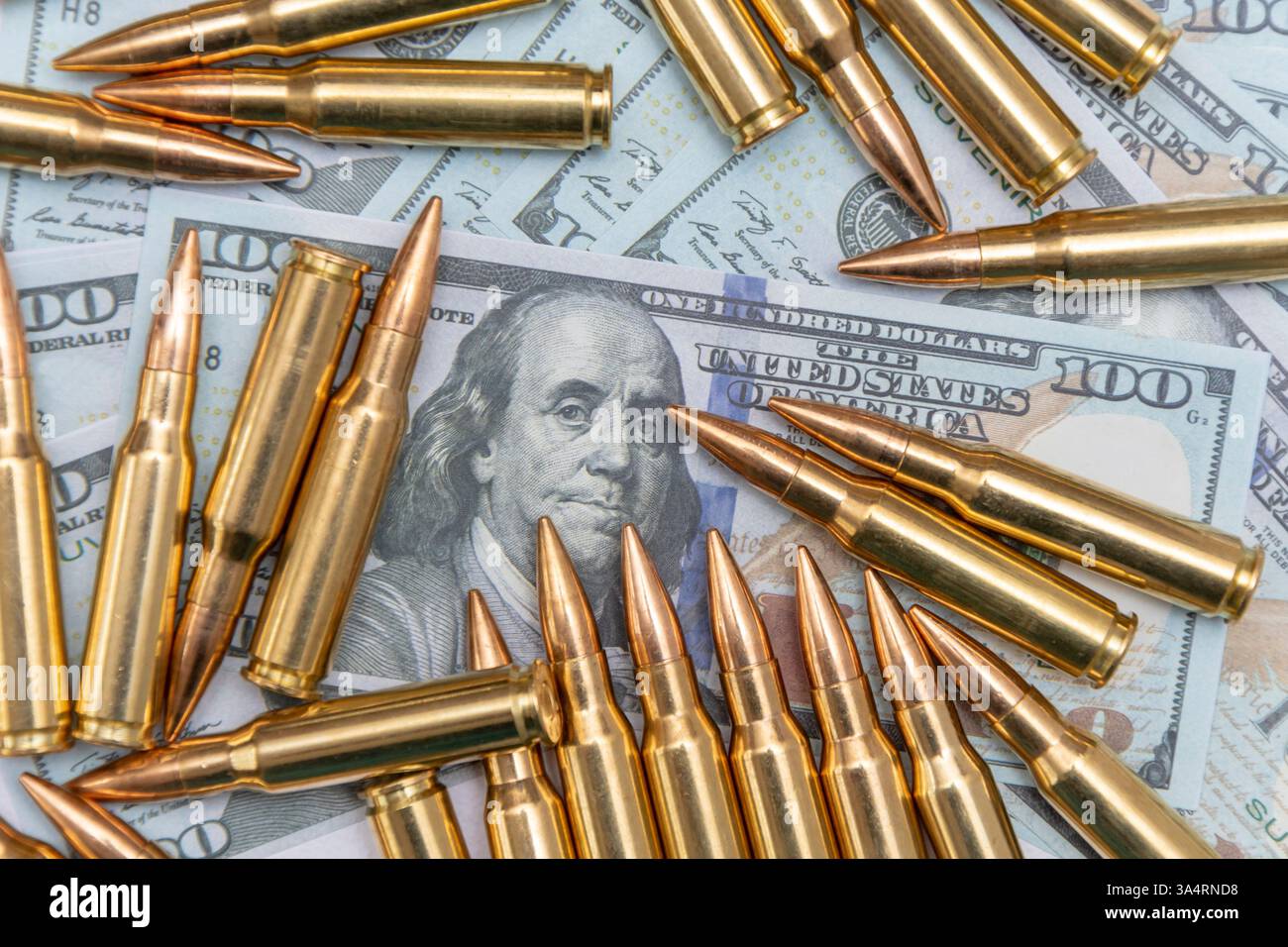 Gelbe Kartuschen und Kartuschen auf 100-Dollar-Scheinen, Nahaufnahme, selektive Fokussierung. Konzept: Verkauf von Waffen im Rahmen von Lend-Leasing, Hilfe mit Waffen Stockfoto