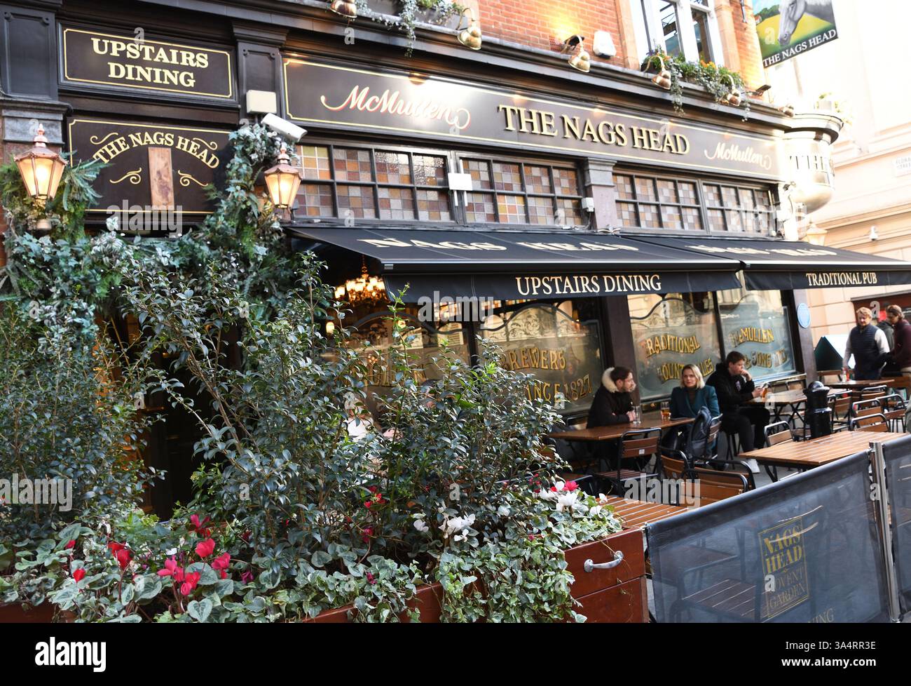 Tische im Freien, The Nag's Head Pub and Restaurant, Covent Garden, City of Westminster, London, Großbritannien. Leute stehen, Leute sitzen an der Tafel Stockfoto