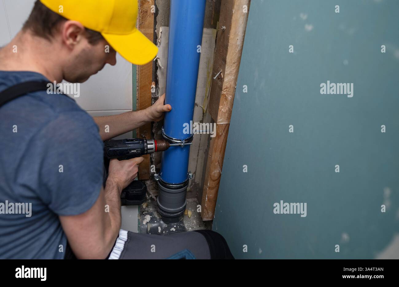 Ein Mann, der einen neuen Abflusskanal installiert. Stockfoto