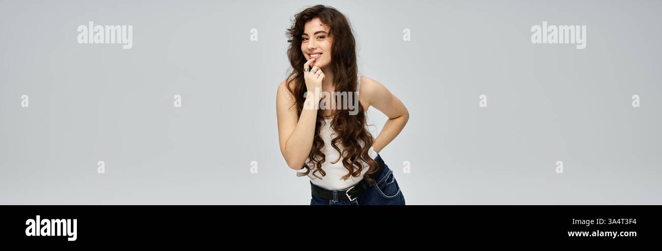 Die verspielte Frau posiert selbstbewusst und zeigt ihr trendiges Modegefühl und ihr charmantes Lächeln. Stockfoto