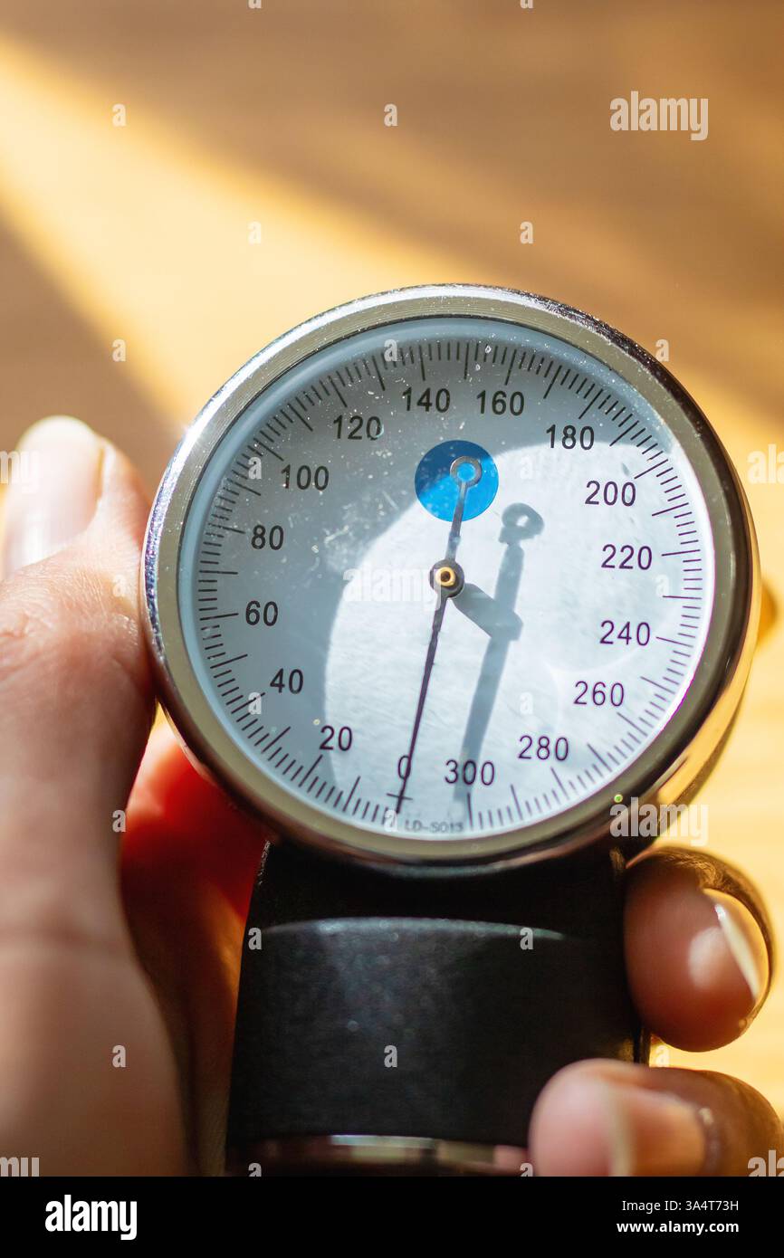 Eine Person hält ein Manometer fest in der Hand und ist bereit, präzise Druckniveaus in verschiedenen Einstellungen zu messen Stockfoto