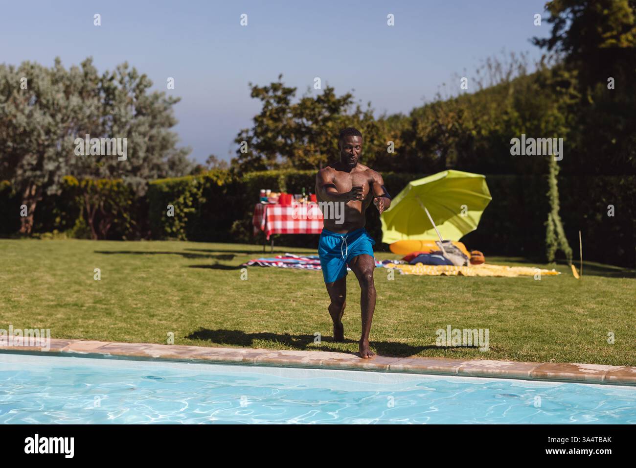 Mann rennt zum Pool, genießt den Sommertag bei einer Party im Freien mit Freunden, Kopierraum Stockfoto