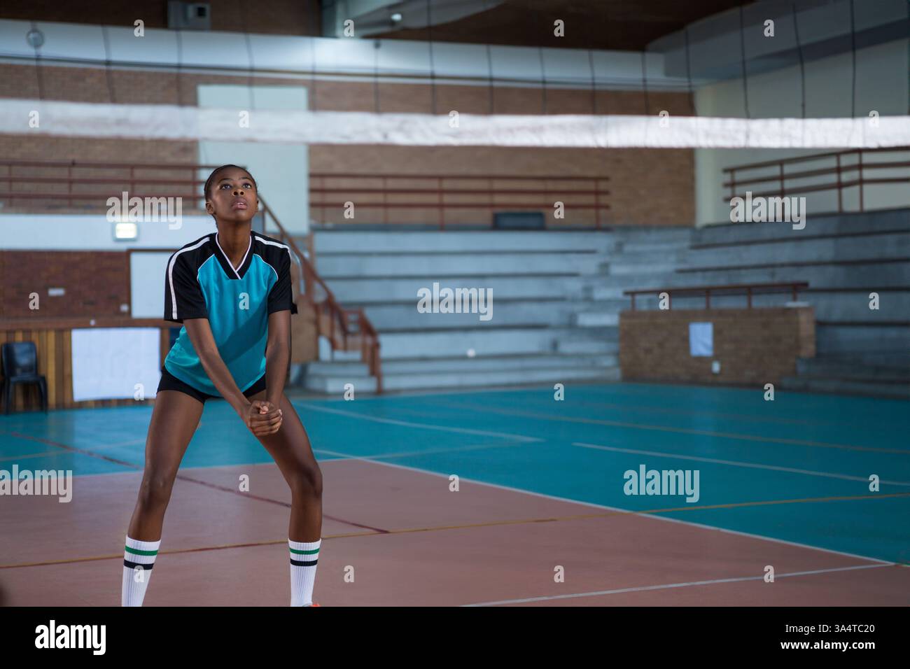 Im Schulgymnasium bereitet sich der Athlet auf Volleyball vor, mit Fokus, Kopierraum Stockfoto