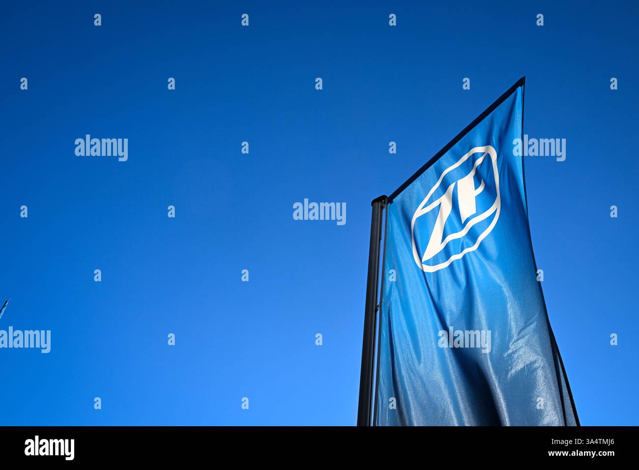 Friedrichshafen, Deutschland. März 2025. Vor dem ZF Friedrichshafen Forum fliegt eine Fahne mit dem ZF Friedrichshafen Logo. Quelle: Felix Kästle/dpa/Alamy Live News Stockfoto