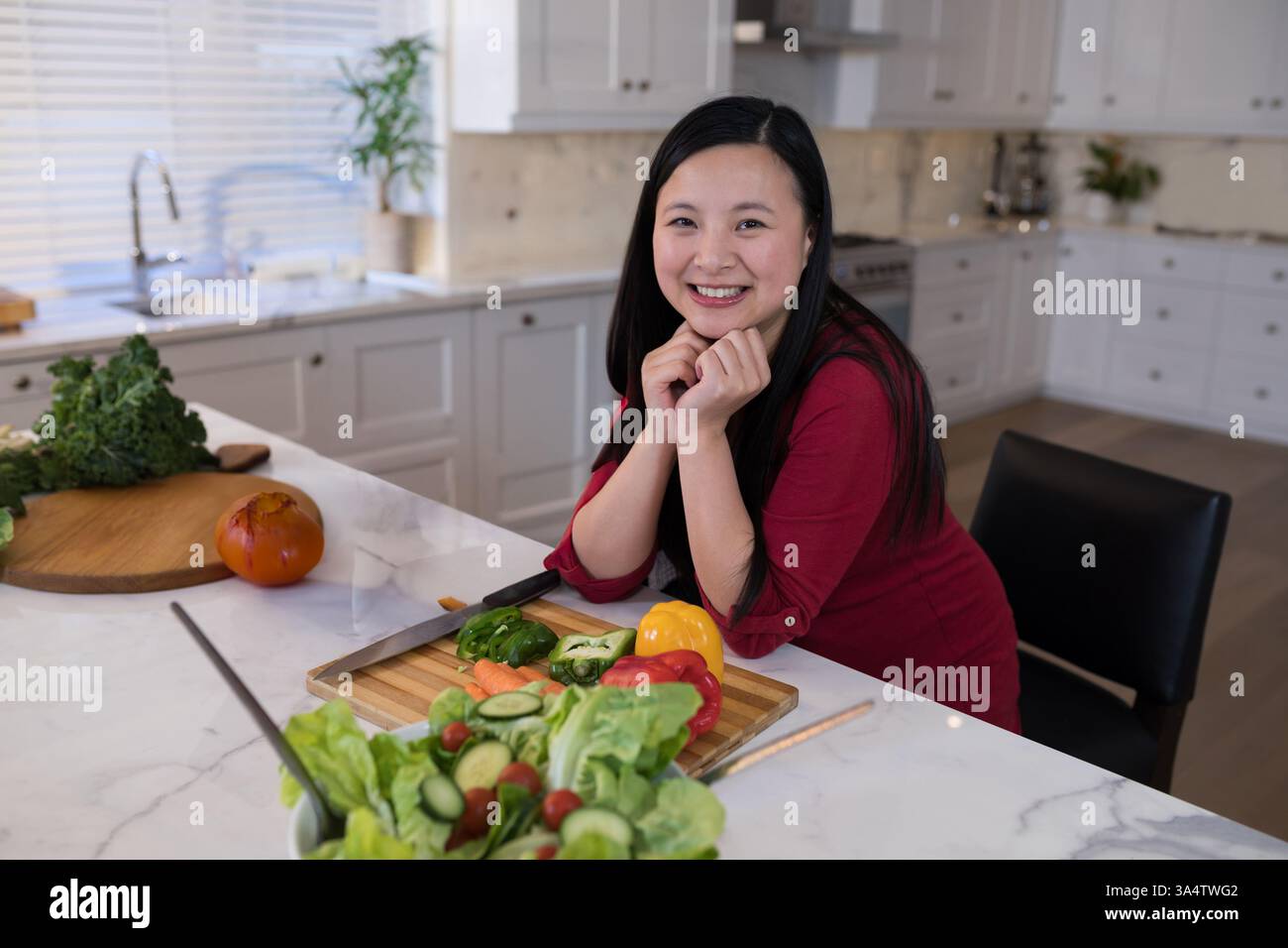 Lächelnde Frau, die frisches Gemüse in der modernen Küche zubereitete, Kochen genießt, Kopierraum Stockfoto