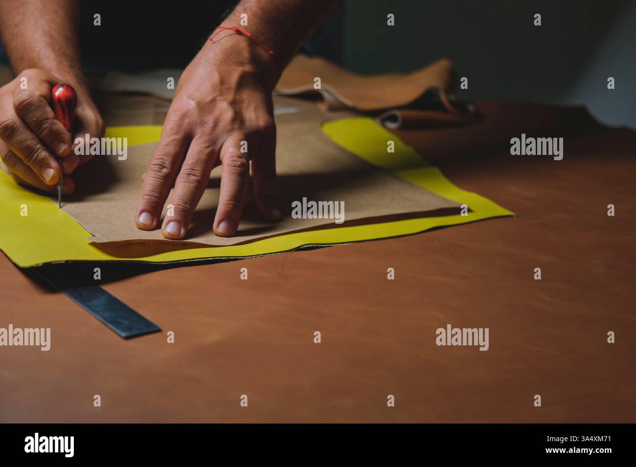 Schuhmacher schneidet Leder mit Präzision und Handwerkskunst Stockfoto
