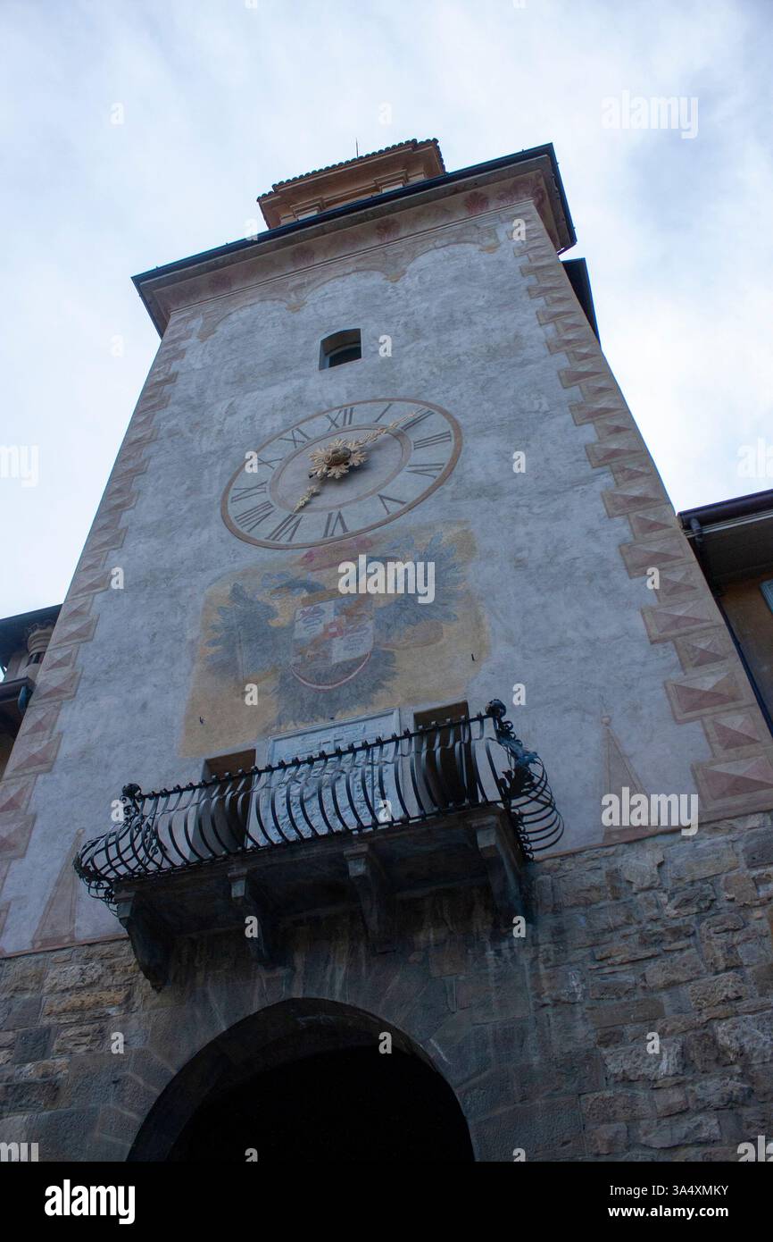 Historischer Uhrenturm mit großer Uhr und Balkon. Verwitterte Erscheinung, römische Zahlen und Torbogen Stockfoto