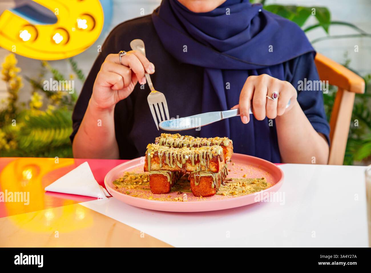 französischer Zimt-Toast mit Pistazienbelag, serviert mit Milchshake in einem schicken Café-Restaurant. Stockfoto
