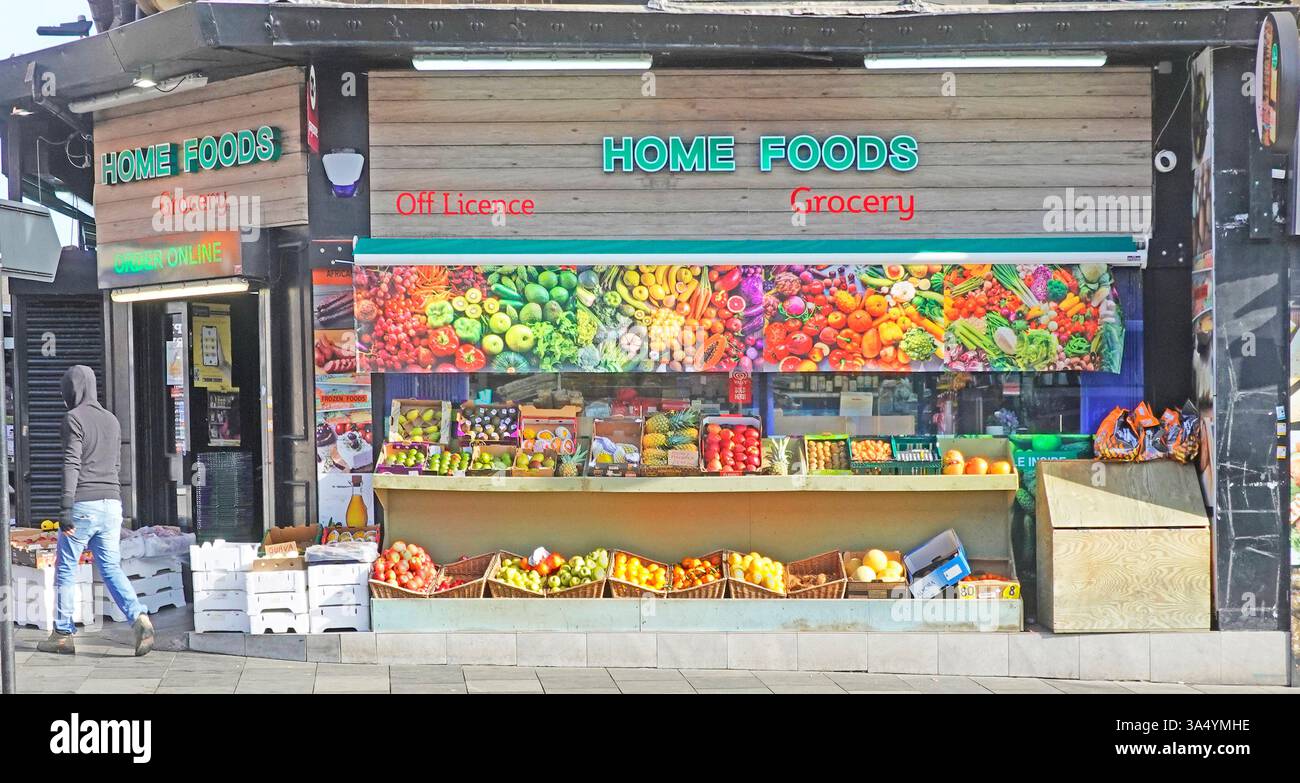 Die farbenfrohe Geschäftsfassade für Lebensmittel und Lebensmittel ohne Lizenz, die durch ein gedrucktes Banner unterstützt wird, wiederholt einige echte Lebensmittel unten im Eckladen Chelmsford Essex UK Stockfoto