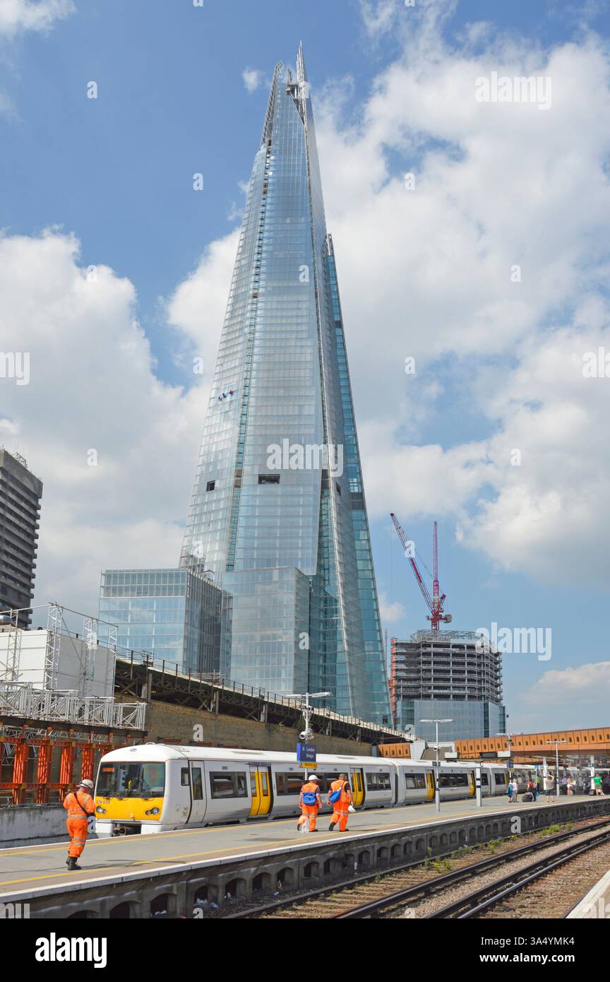 Blick auf das Gebäude des Shard Wolkenkratzers vom Bahnhof London Bridge aus, Arbeiter in gut sichtbarer Sicherheitskleidung Southwark England UK Stockfoto