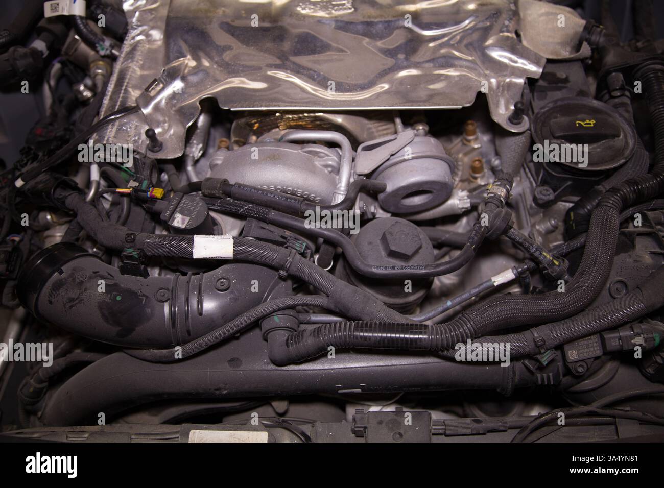 Die entfernte Motorabdeckung im Motorraum eines untergetauchten Autos Stockfoto