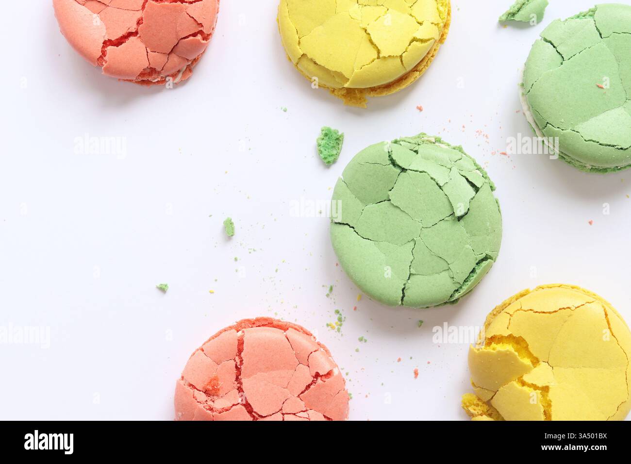 Helle mehrfarbige französische Macarons auf hellem Hintergrund, Draufsicht. Auswahl an Macarons mit verschiedenen Geschmacksrichtungen. Köstliches Gebäck. Zerknittert Stockfoto