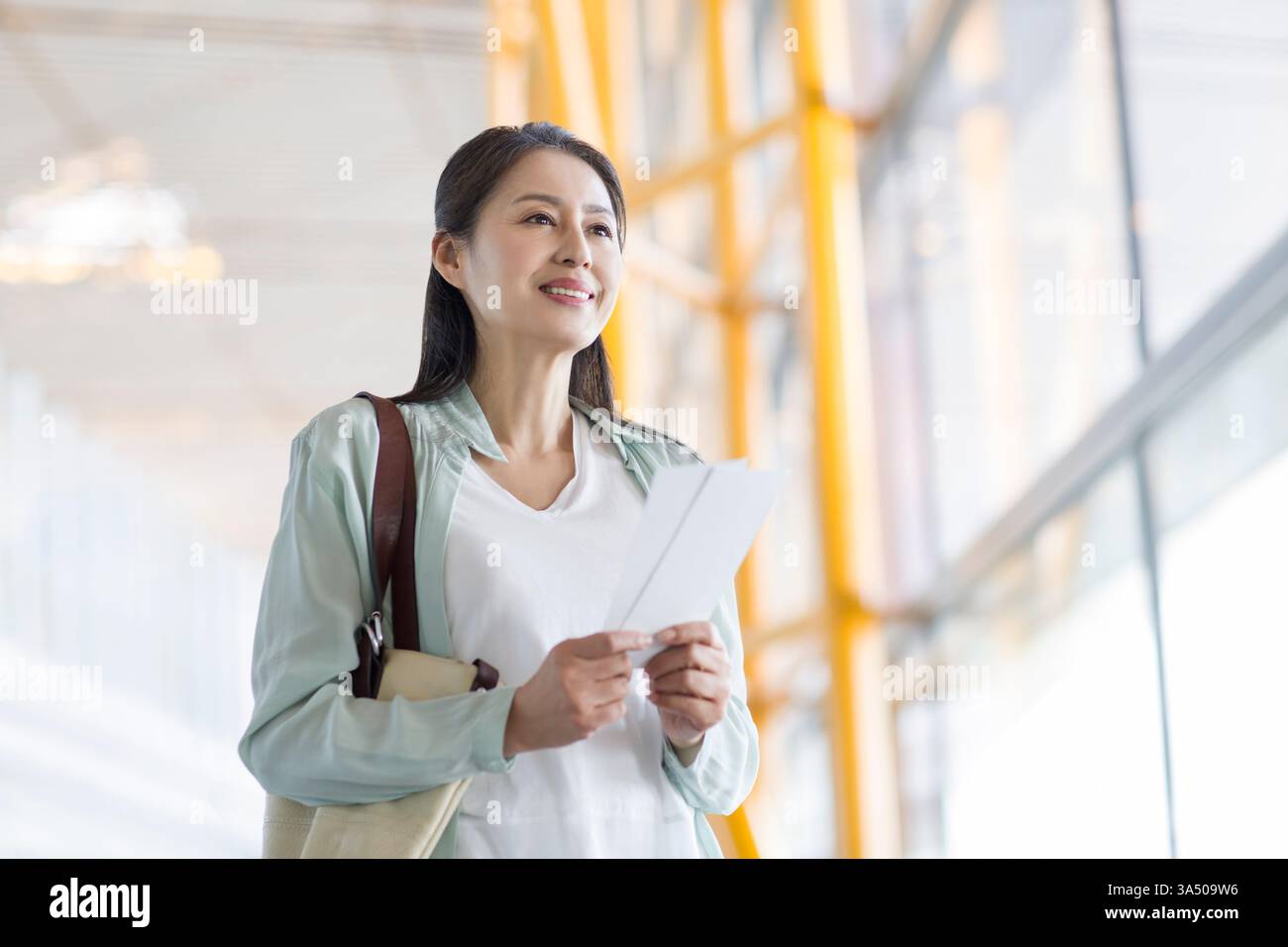 Reife Chinesin wartet am Flughafen Stockfoto