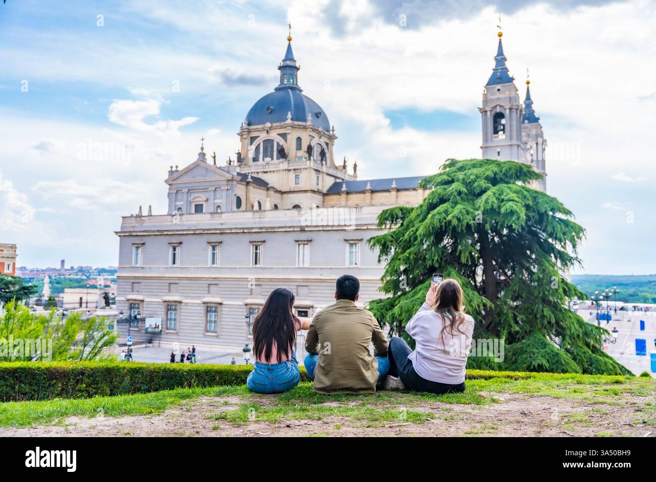 Asiatischer Mann und kaukasische Frau fotografierten im Urlaub im Freien, während sie in der Nähe einer Kathedrale posierten. Ein fröhlicher Reisemoment, geeignet für Tourismus, Städtereisen und multikulturelle Erlebnisse. Stockfoto