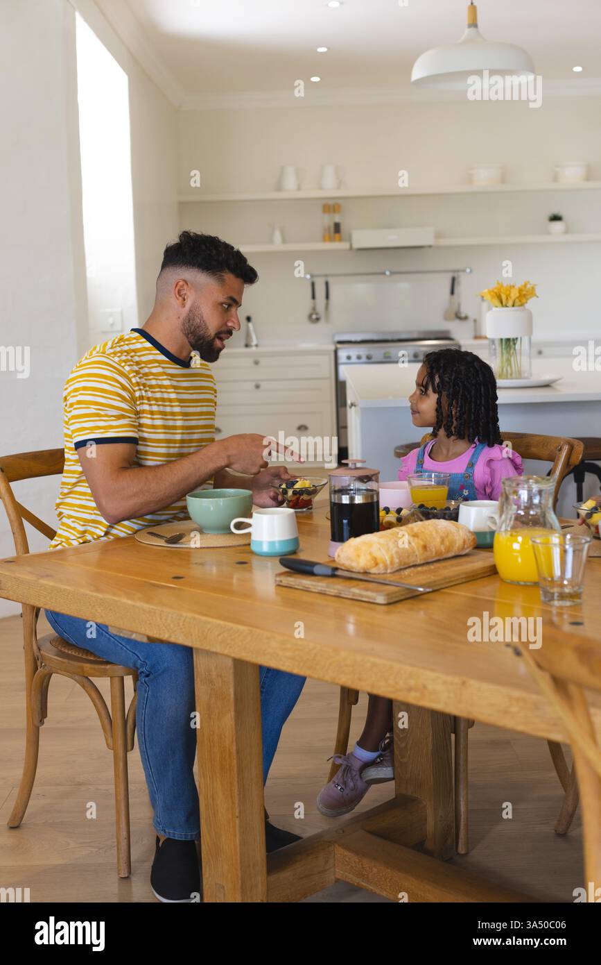 Vater und Tochter genießen gemeinsam zu Hause Frühstück, tauschen Gespräche aus, kopieren Platz Stockfoto