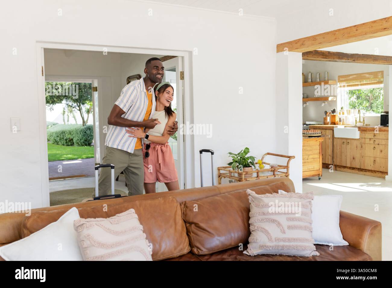 Afroamerikaner, Mann und Frau, die mit dem Gepäck ins Ferienhaus gehen, aufgeregt aussehen, Kopierraum Stockfoto