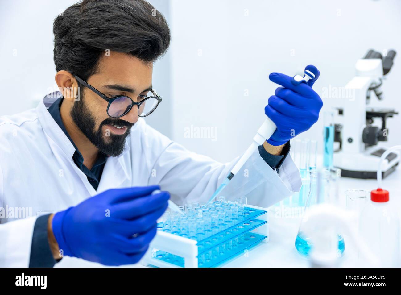 Ein Wissenschaftler mit Handschuhen arbeitet in einem Labor und führt Experimente durch, um neue Medikamente zu entdecken. Geeignet für Biotechnologie, pharmazeutische Forschung und wissenschaftliche Bildung. Stockfoto