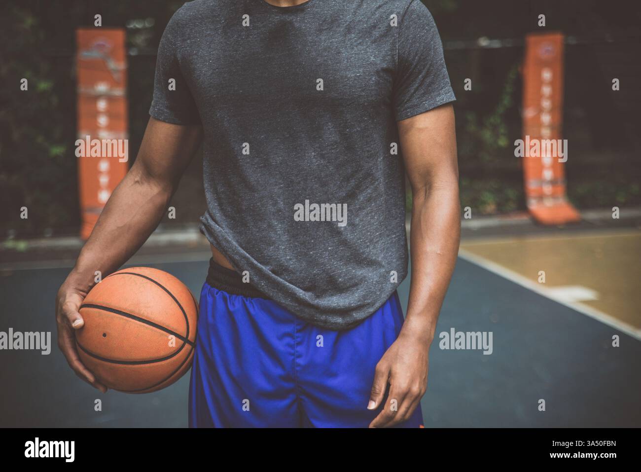 Urbanes Basketballtraining auf einem New York City Court, mit Fokus und Energie. Ein dynamisches Sportimage mit einem männlichen Spieler in einer städtischen Umgebung, ideal für Fitness, Basketball und Urban Lifestyle Promotions. Stockfoto