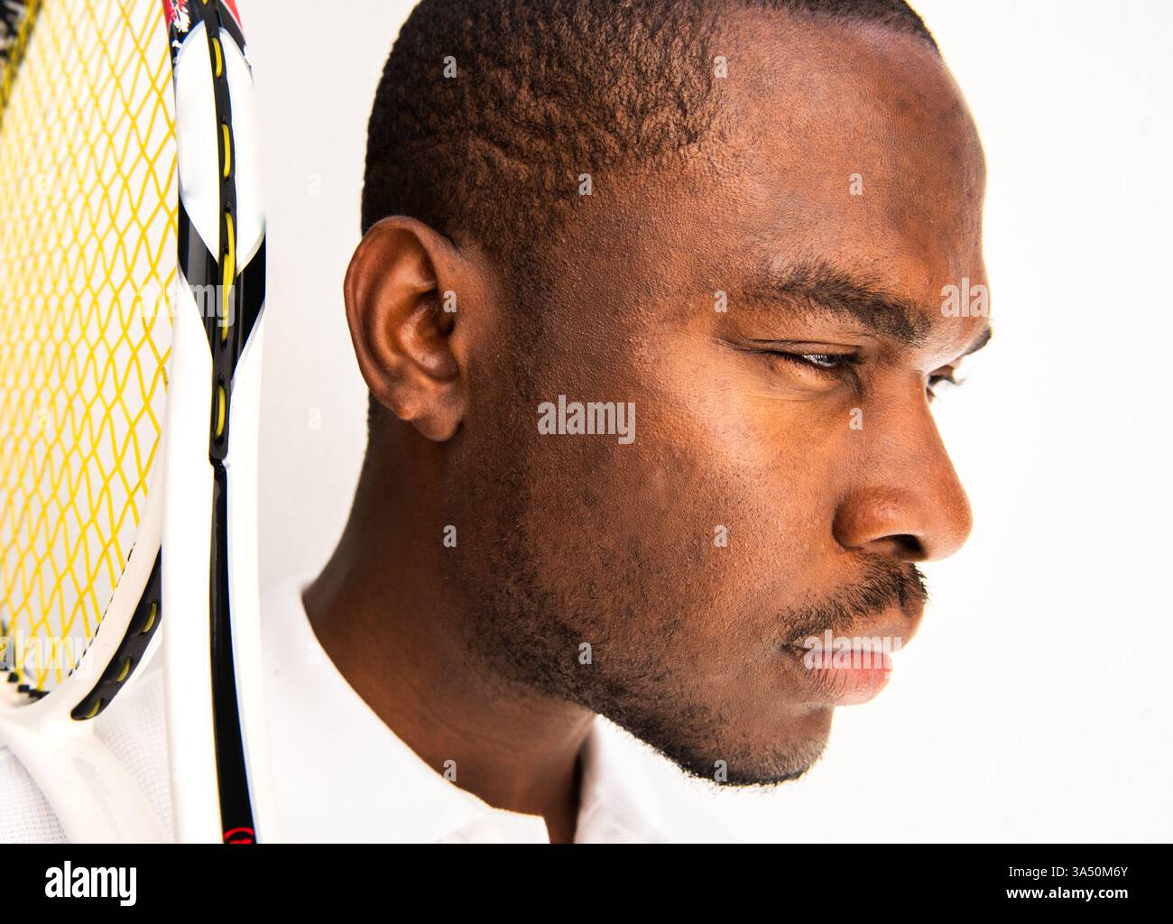 Nahaufnahme eines Afroamerikaners mit Tennisschläger. Dieses athletische Bild vermittelt Fokus und Entschlossenheit für Sport- und Fitnesskontexte. Stockfoto