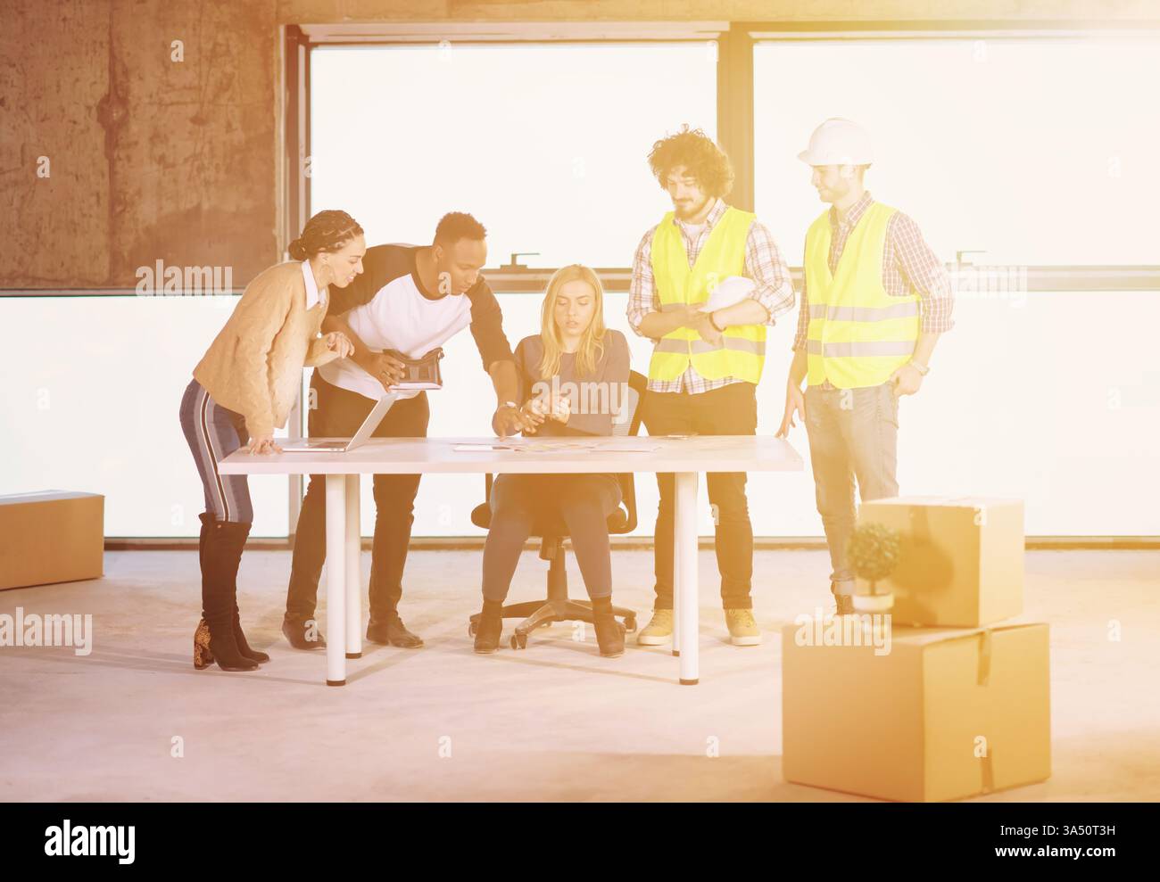 Ein junges, multiethnisches Geschäftsteam auf einer Baustelle überprüft Dokumente und Arbeitsabläufe mit einem VR-Headset und einem Laptop. Das Bild vermittelt Zusammenarbeit, Innovation und Technologie für die Feldforschung. Perfekt für Themen wie Bauwesen, Unternehmenstechnologie und verschiedene Teams. Stockfoto