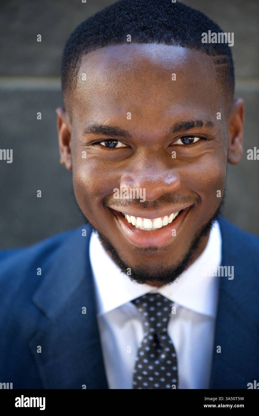 Nahaufnahme eines fröhlichen nigerianischen Geschäftsmannes, der selbstbewusst lächelt. Ein professioneller Headshot, der sich für Unternehmensprofile, Führungspositionen und Geschäftskommunikation eignet. Ideal für Marketingmaterialien und Bilder für Führungskräfte. Stockfoto