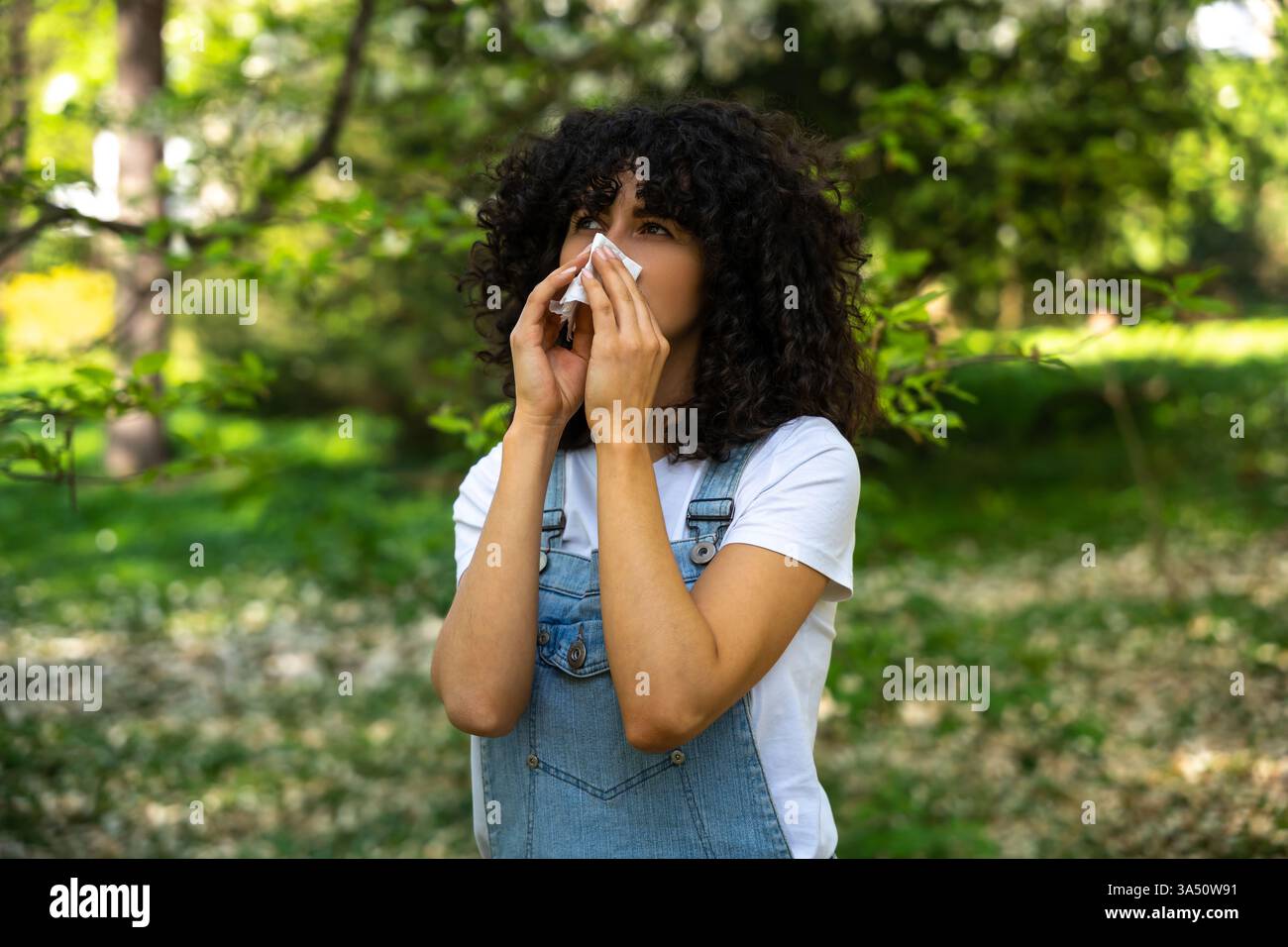 Lockhaarige Mischrassenfrau mit saisonaler Allergie Stockfoto