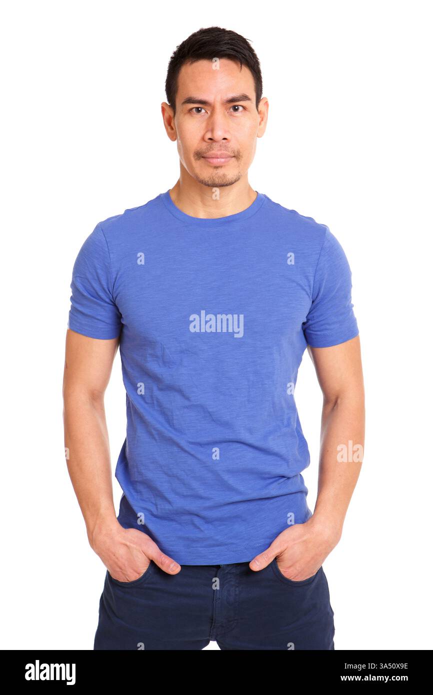 Porträt eines asiatischen Mannes, der mit Händen in Taschen vor einem sauberen weißen Hintergrund steht. Die lässige Haltung und der selbstbewusste Look machen dieses Modell vielseitig für Lifestyle, Business oder Unternehmenskampagnen. Stockfoto