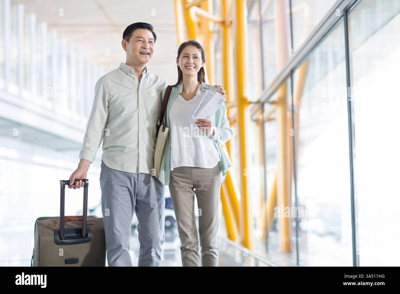 Reifes chinesisches Paar, das mit Koffer zum Flughafen ging Stockfoto