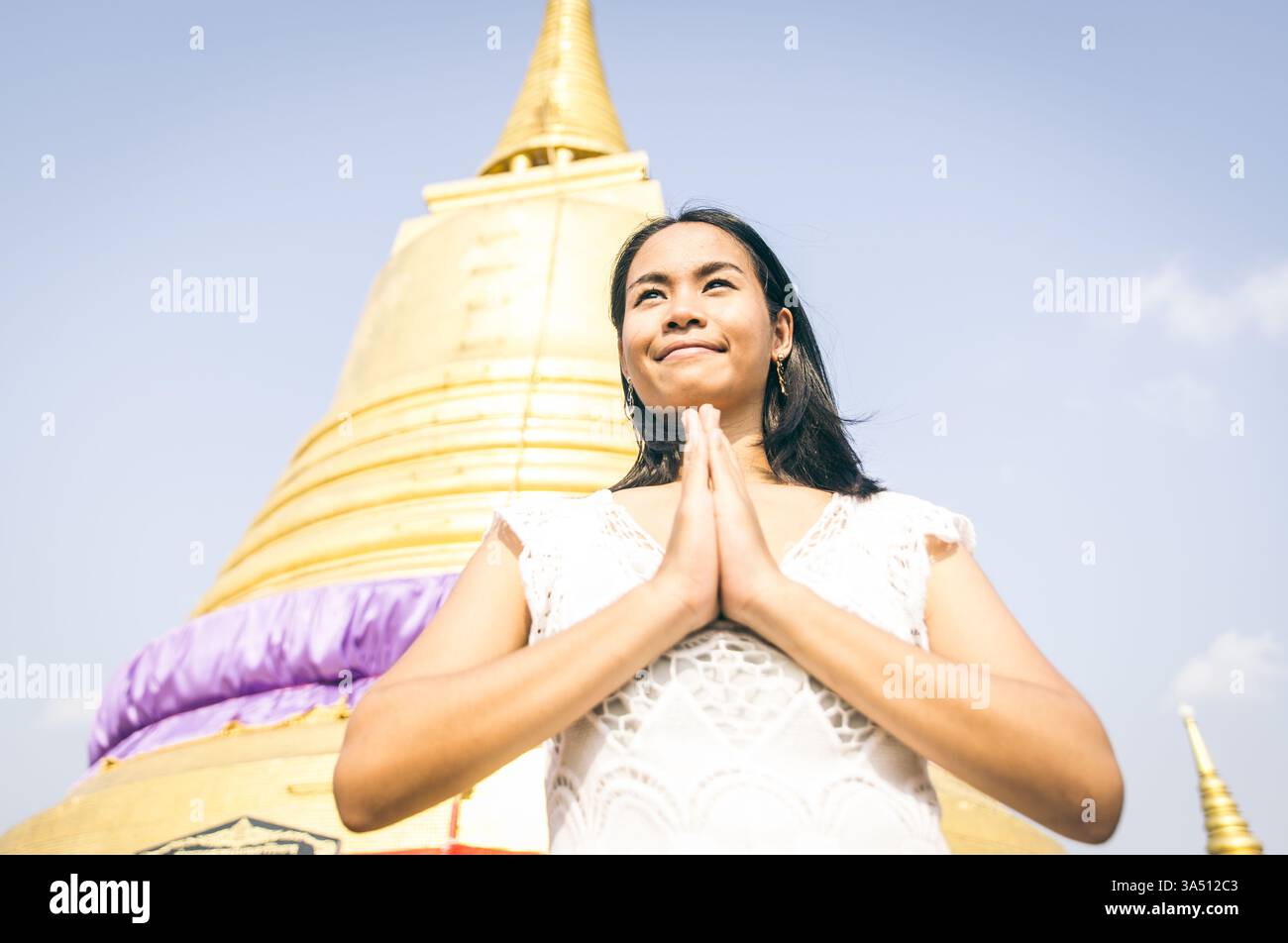 Thai-Frau betet in einem buddhistischen Tempel. Bild des kulturellen und spirituellen Lebensstils, geeignet für Reise-, Religions- und Tempelfotografie. Ideal für südostasiatische Grafiken und historische Kontexte. Stockfoto