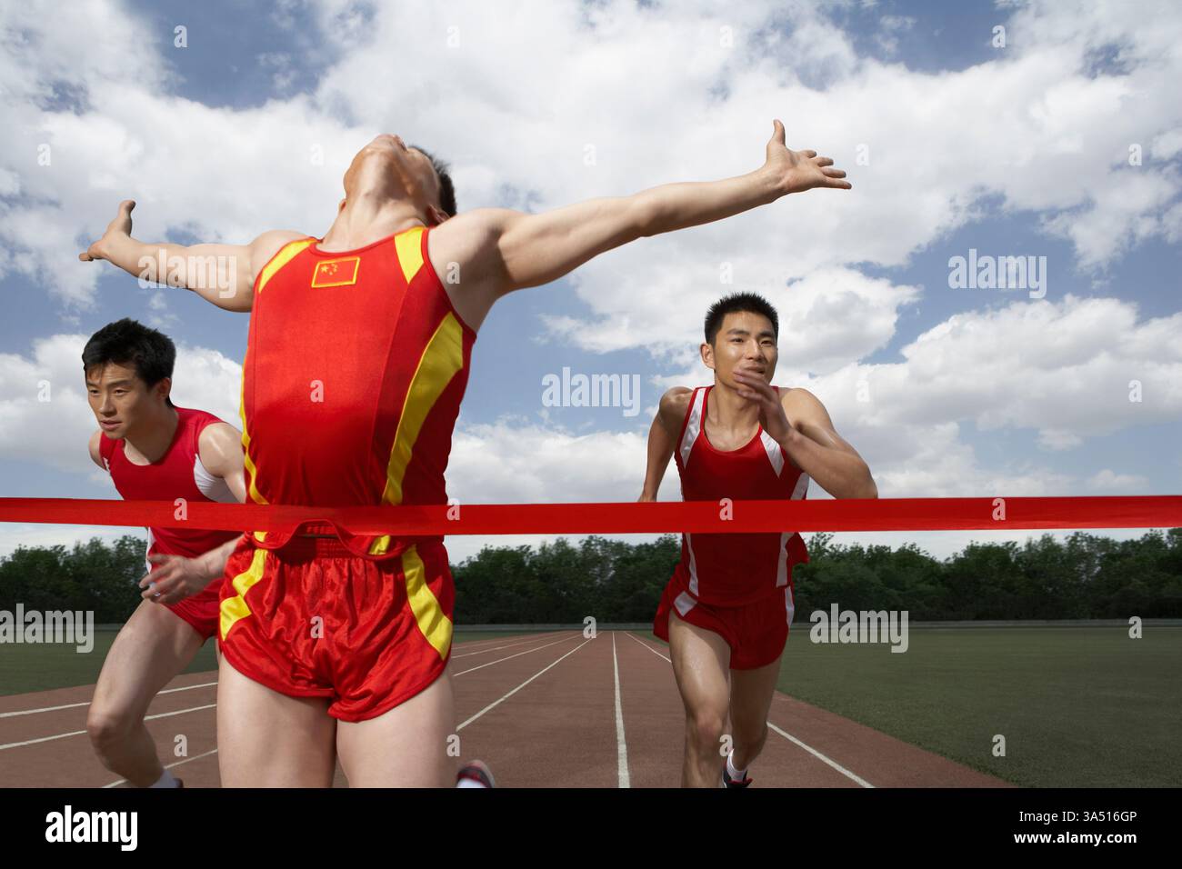 Ein chinesischer Athlet läuft auf einer Strecke, sprintet in einem Wettkampf. Dynamische Track- und Field-Bilder, die Geschwindigkeit und Sportlichkeit hervorheben. Geeignet für Sportkampagnen, Fitness und nationale oder Teamgeist. Stockfoto