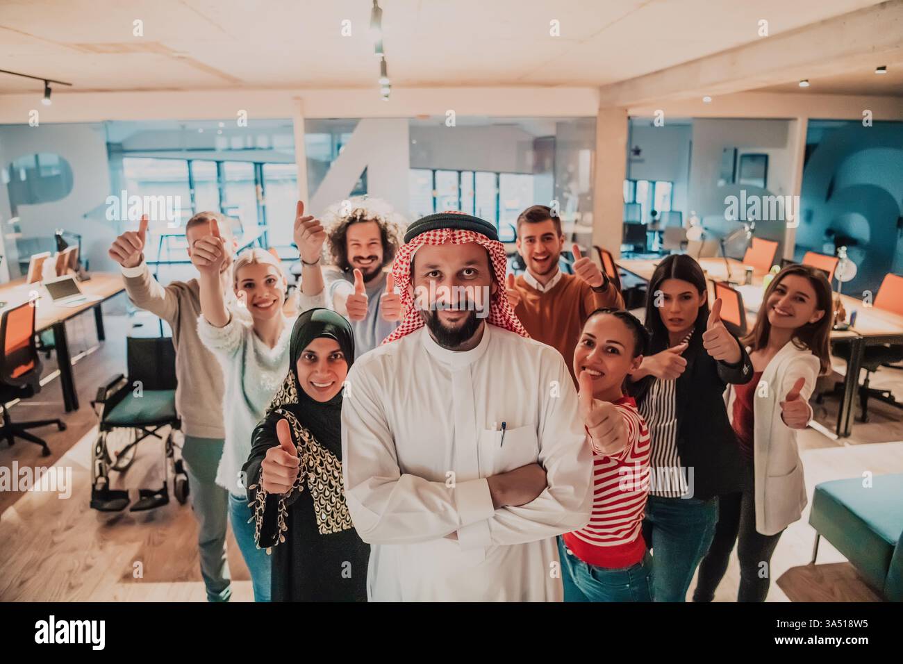 Eine vielfältige Gruppe erfolgreicher Geschäftsleute in einem modernen Glasbüro steht zusammen, geführt von einer Persönlichkeit an der Spitze. Ein qualitativ hochwertiges Image, das Vielfalt, Führungsstärke und Teamarbeit am Arbeitsplatz betont. Geeignet für Unternehmenskommunikation, Geschäftstreffen und multikulturelle Teams. Stockfoto