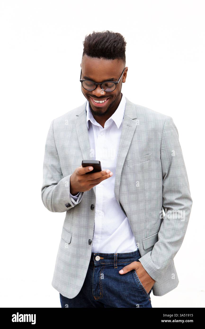 Der lächelnde Schwarze Mann in Brille benutzt ein Smartphone vor reinweißem Hintergrund. Ein vielseitiges Image für Geschäfts- und Technologiekontexte mit modernem, ansprechendem Flair. Stockfoto