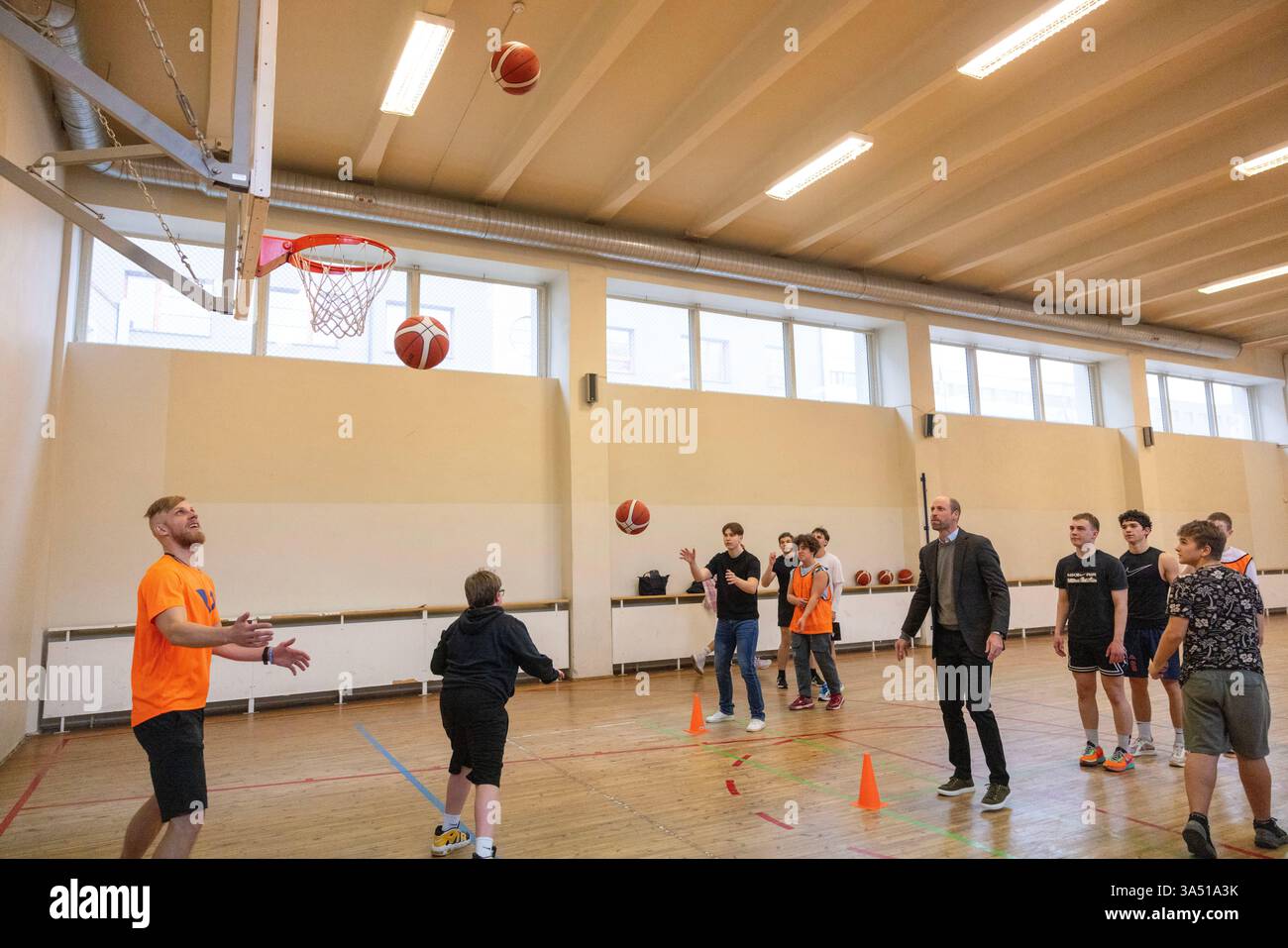 Der Prinz von Wales beobachtet die Schüler beim Basketball während eines Besuchs der Freiheitsschule in Tallinn, die vom Ministerium für Bildung und Forschung Estlands im Mai 2022 gegründet wurde, um auf den Krieg in der Ukraine zu reagieren, am ersten Tag seines Besuchs in Estland. Bilddatum: Donnerstag, 20. März 2025. Stockfoto