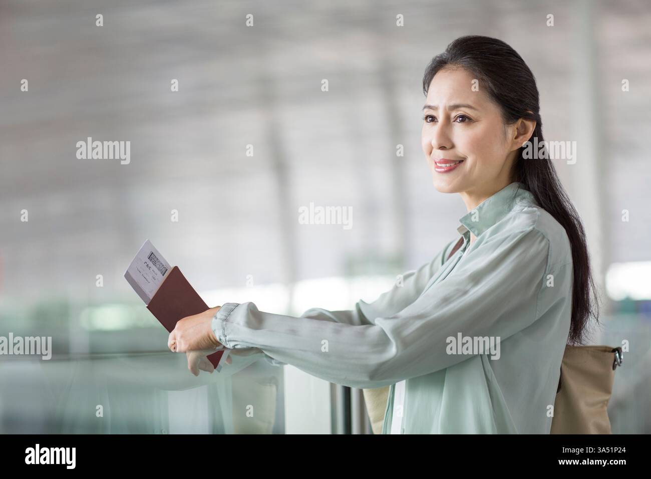Reife Chinesin wartet am Flughafen Stockfoto