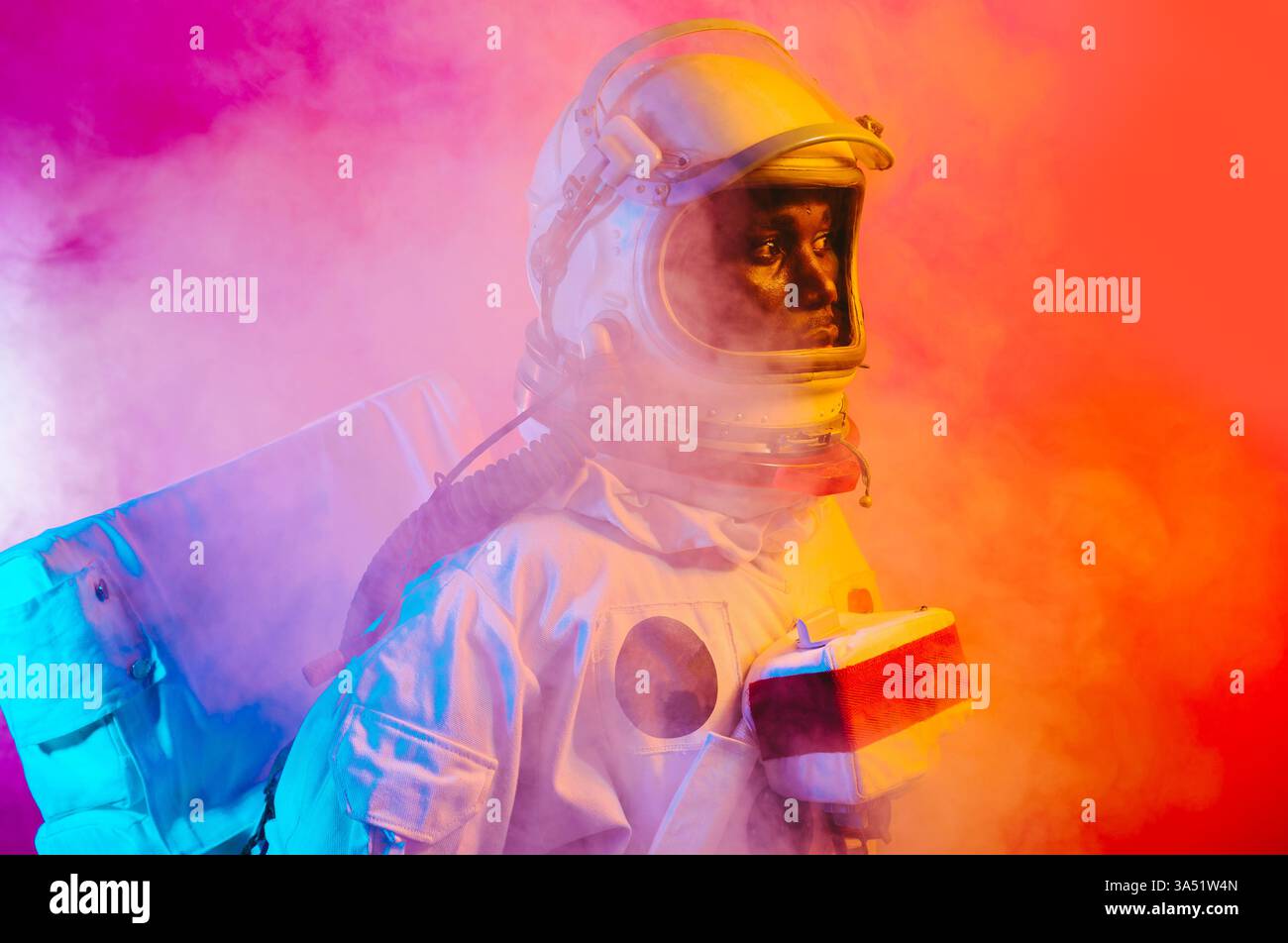 Filmisches Porträt eines Mannes in einem Raumanzug, das an ein Astronautenthema erinnert. Lebendige Bilder für den Weltraum und den naturwissenschaftlichen Lebensstil, geeignet für Technologie- und Explorationsbranding. Stockfoto