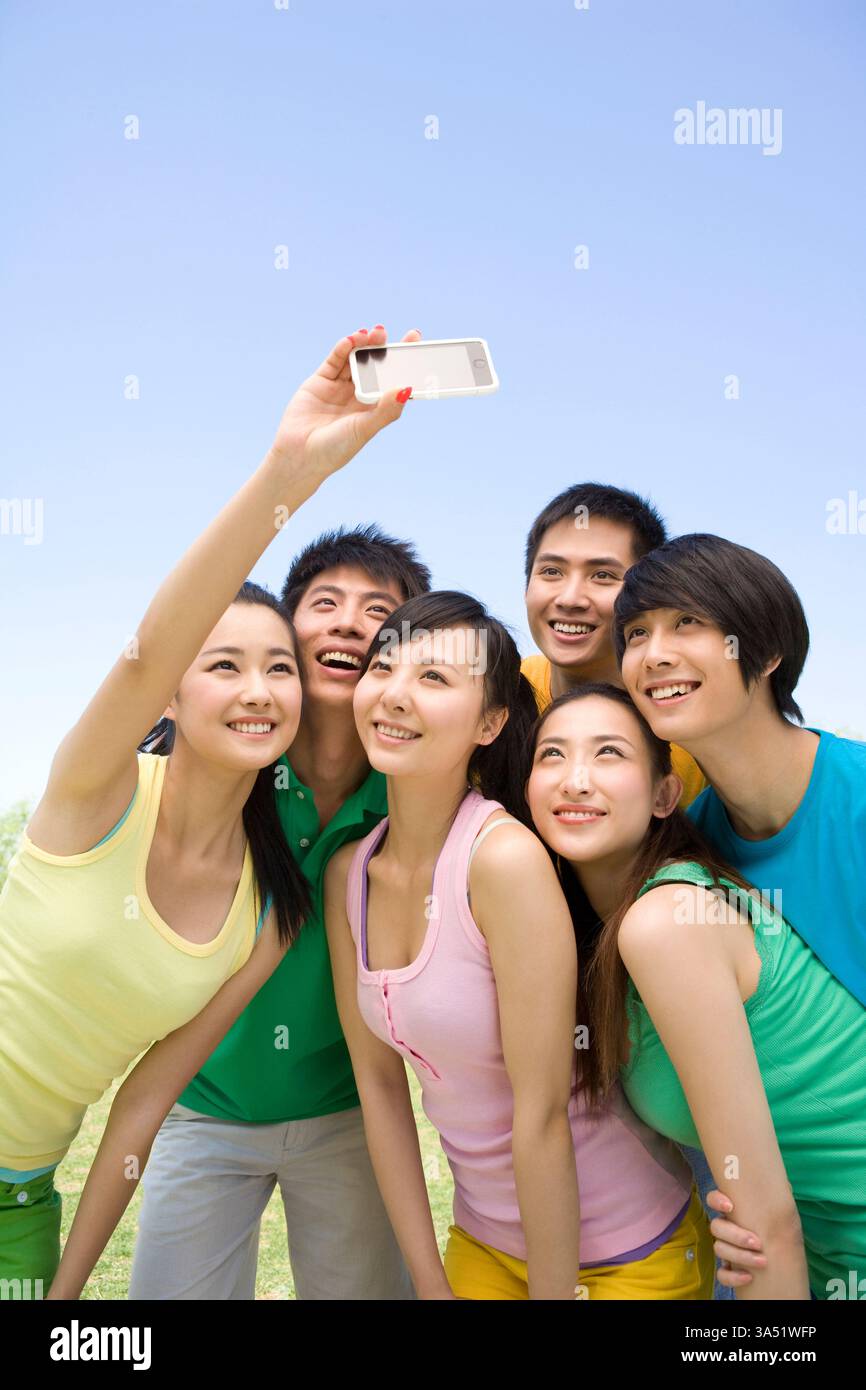 Gruppe chinesischer Freunde, die gemeinsam ein Foto machen und einen Moment der Freundschaft genießen. Die Szene vermittelt Jugendliche, soziale Beziehungen und zeitgenössische Fotoaktivitäten, ideal für Lifestyle- und Reiseinhalte in Asien. Geeignet für Kampagnen, die auf frische, multikulturelle Erlebnisse abzielen. Stockfoto