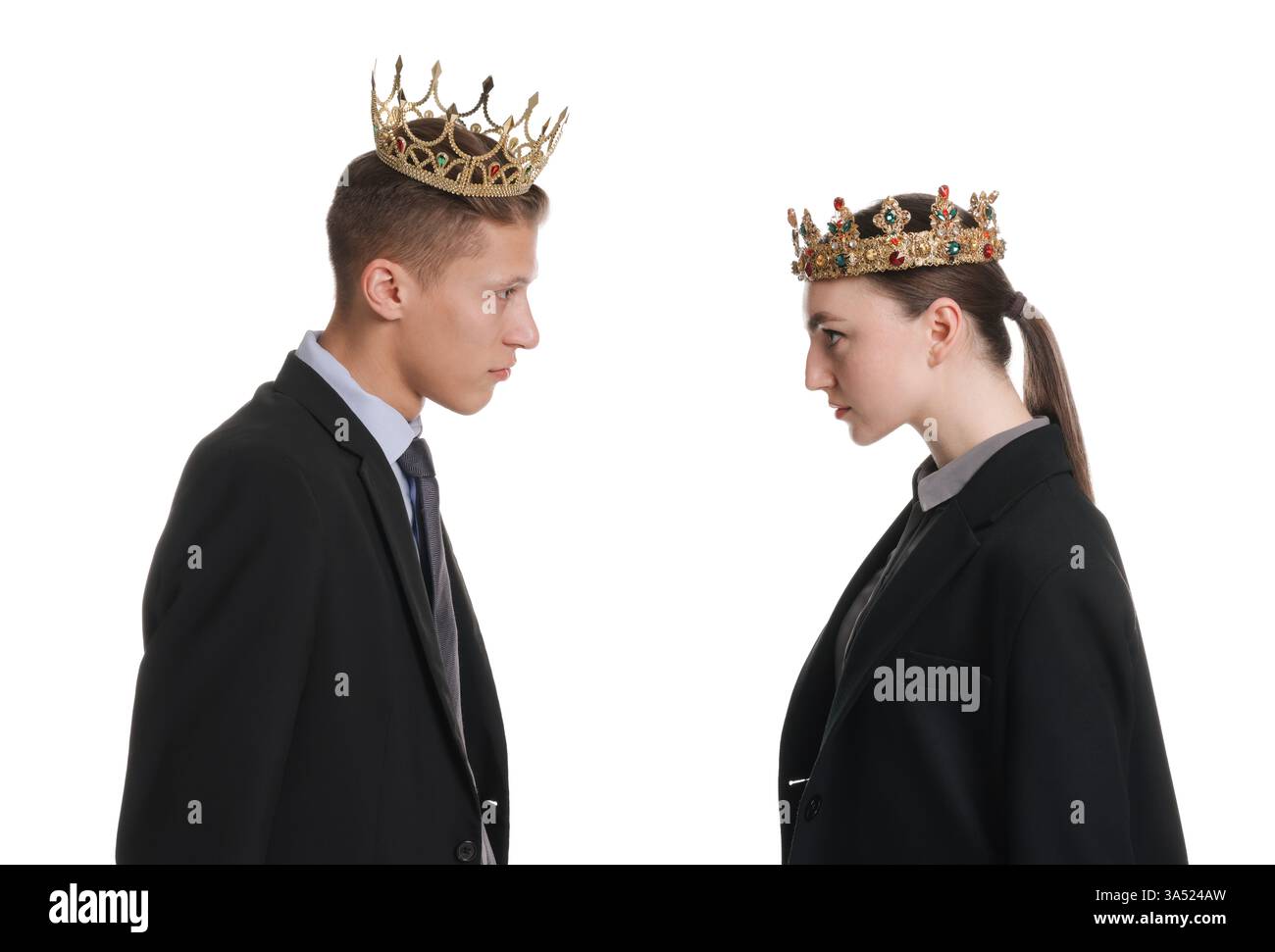 Unternehmenswettbewerb. Kollegen in goldenen Kronen, die sich auf weißem Hintergrund ansehen Stockfoto