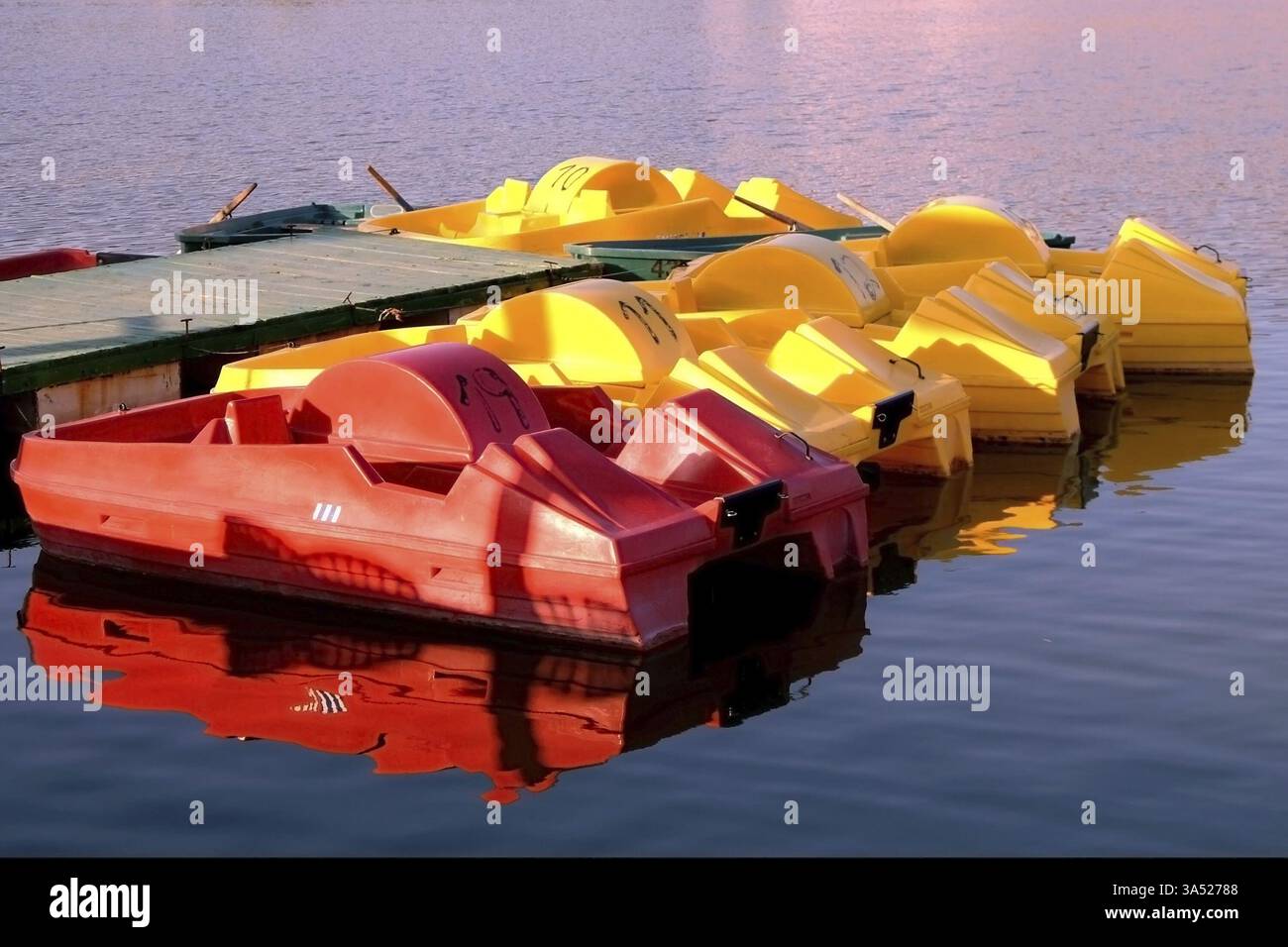 Auf einem Dock bunte Boote auf einem Dock in einem Teich Stockfoto