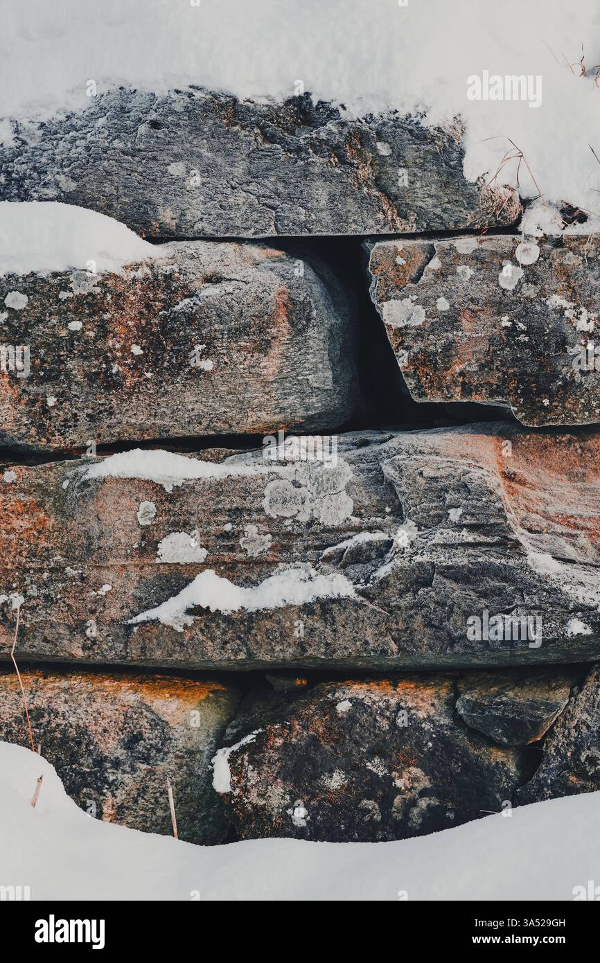 Steinfundament einer verlassenen Scheune im Schnee. Stockfoto