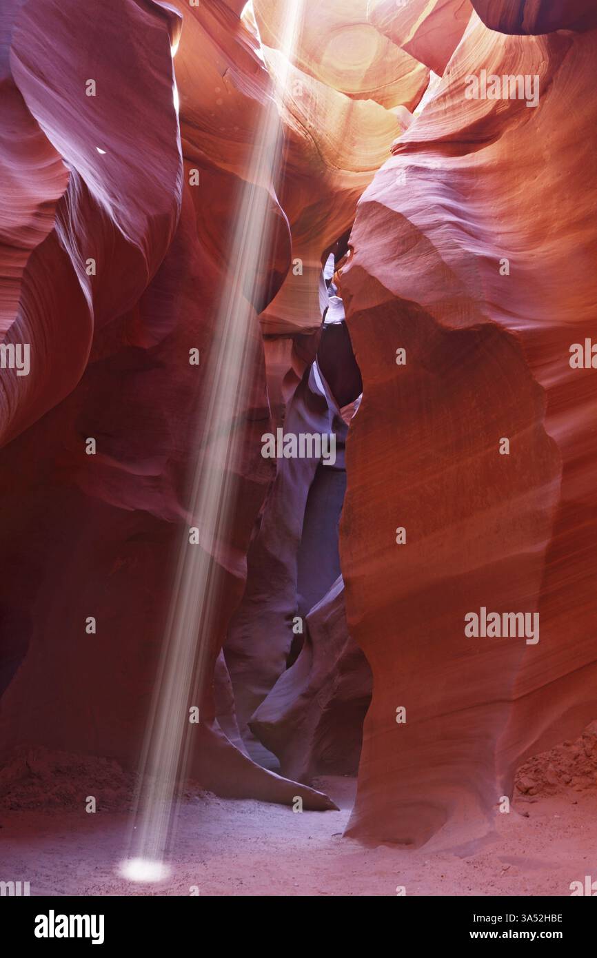 Mittags im Antelope Canyon. Ein dünner Sonnenstrahl beleuchtet den sandigen Boden des Canyons Stockfoto