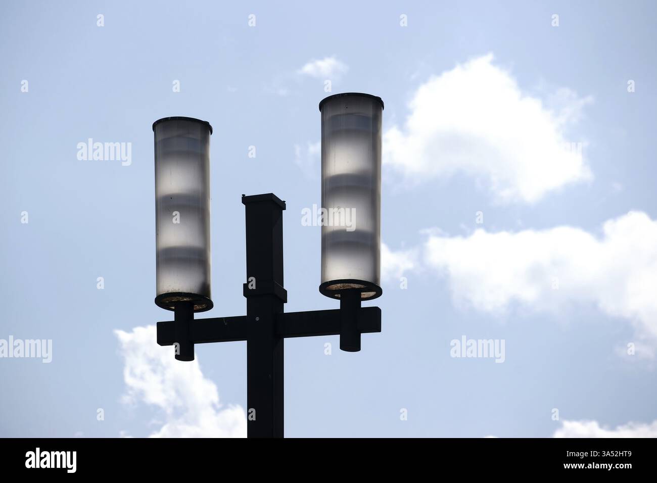 Die zwei lampenschirmen eines modernen Straßenlaterne vor einem blauen Himmel mit Wolken Stockfoto