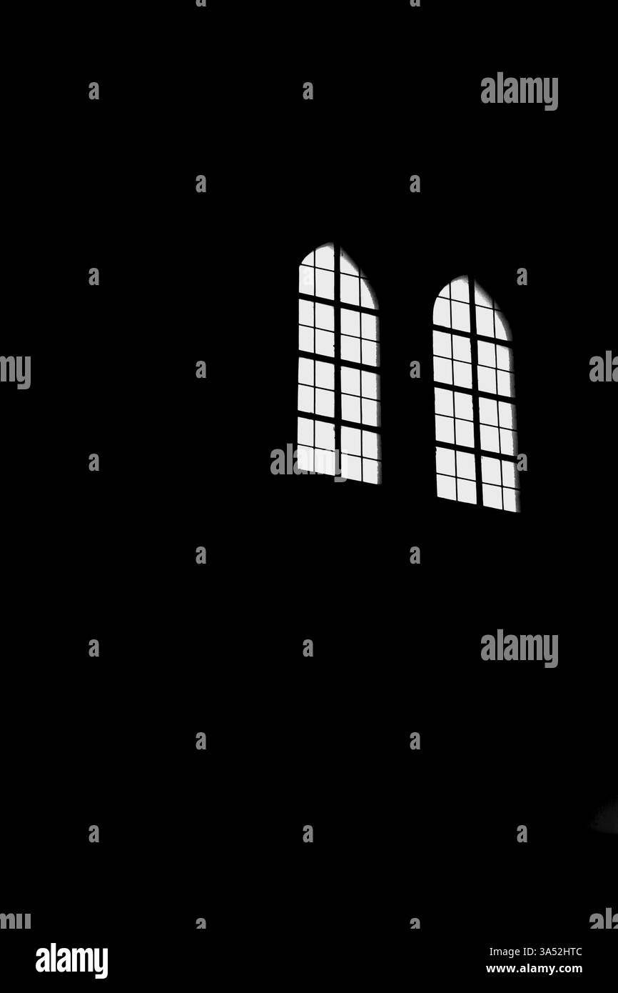 Ein beleuchtetes gotisches Kirchenfenster auf schwarzem Hintergrund Stockfoto